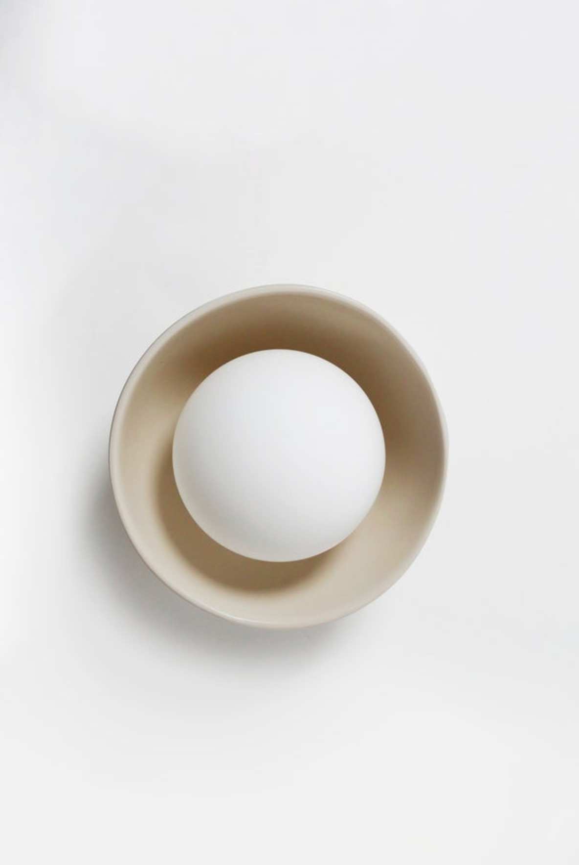 White ball inside a beige bowl on a white background