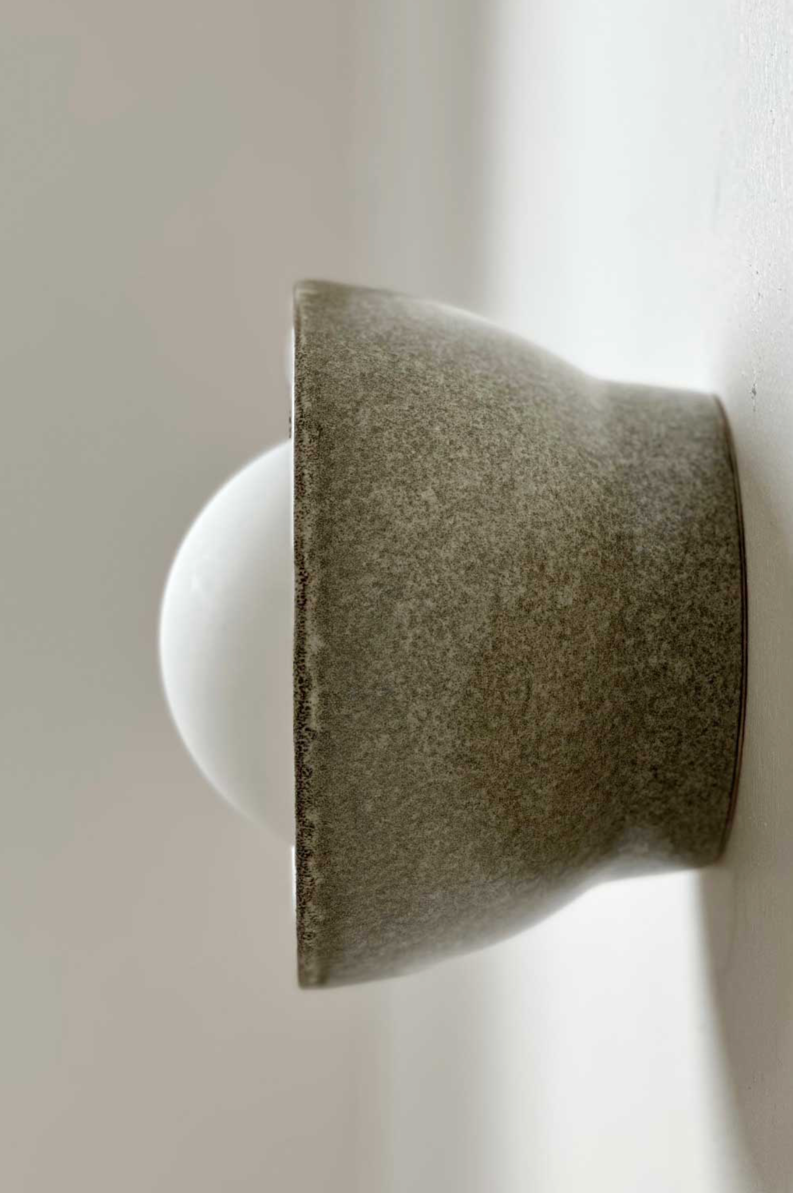 Ceramic indoor wall light on a neutral wall