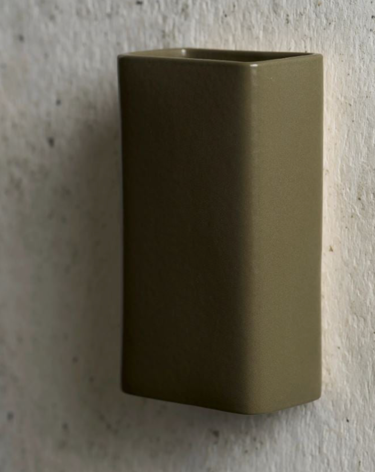 Green rectangular wall-mounted on a textured wall