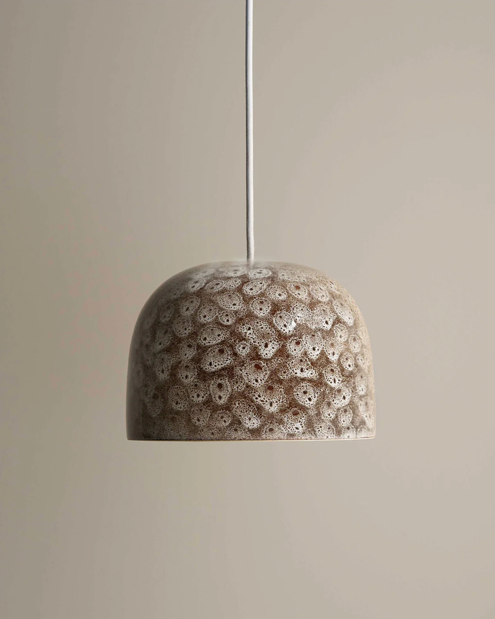 Decorative ceramic textured pendant light with pattern on a plain background