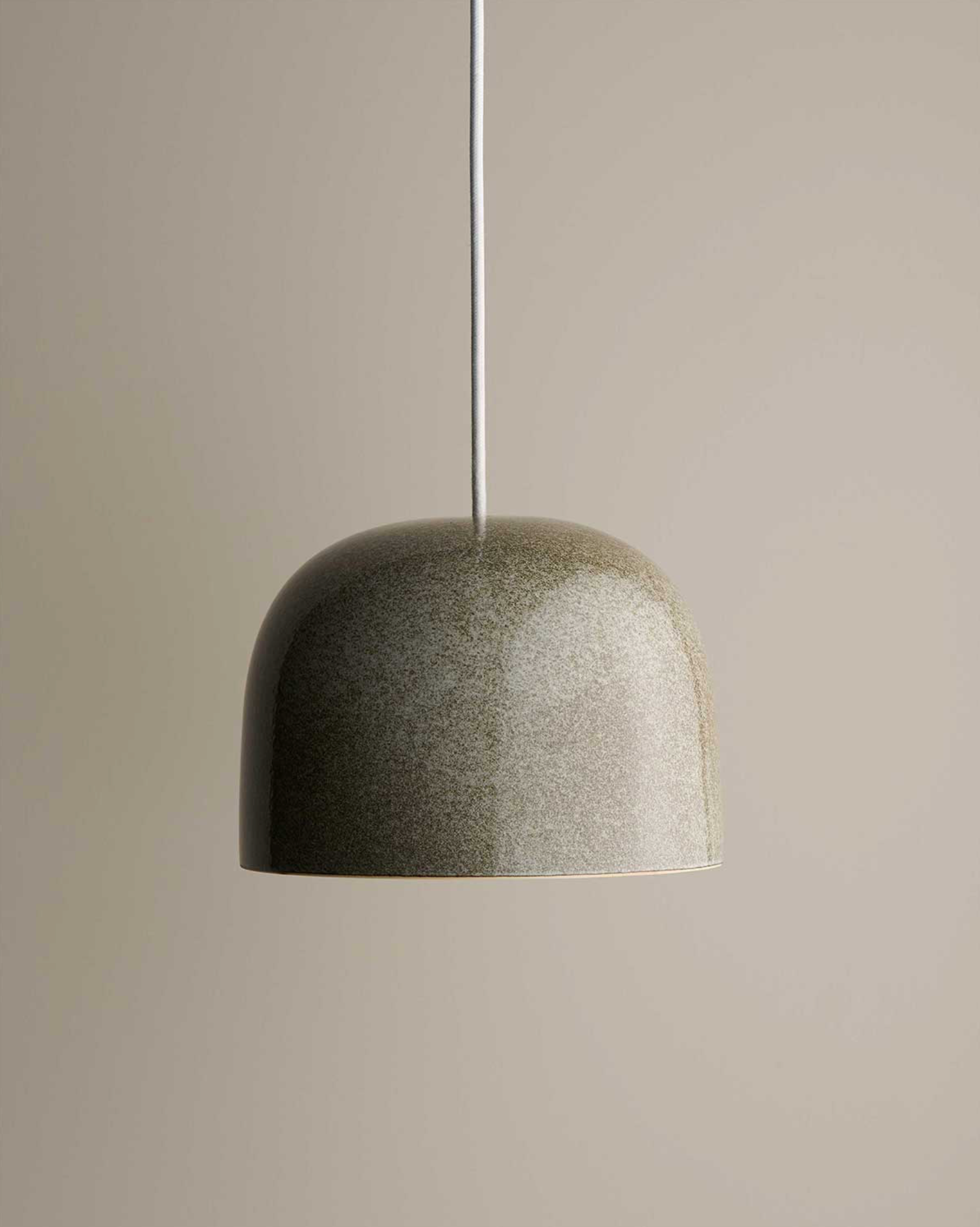 Textured ceramic pendant light on a neutral background
