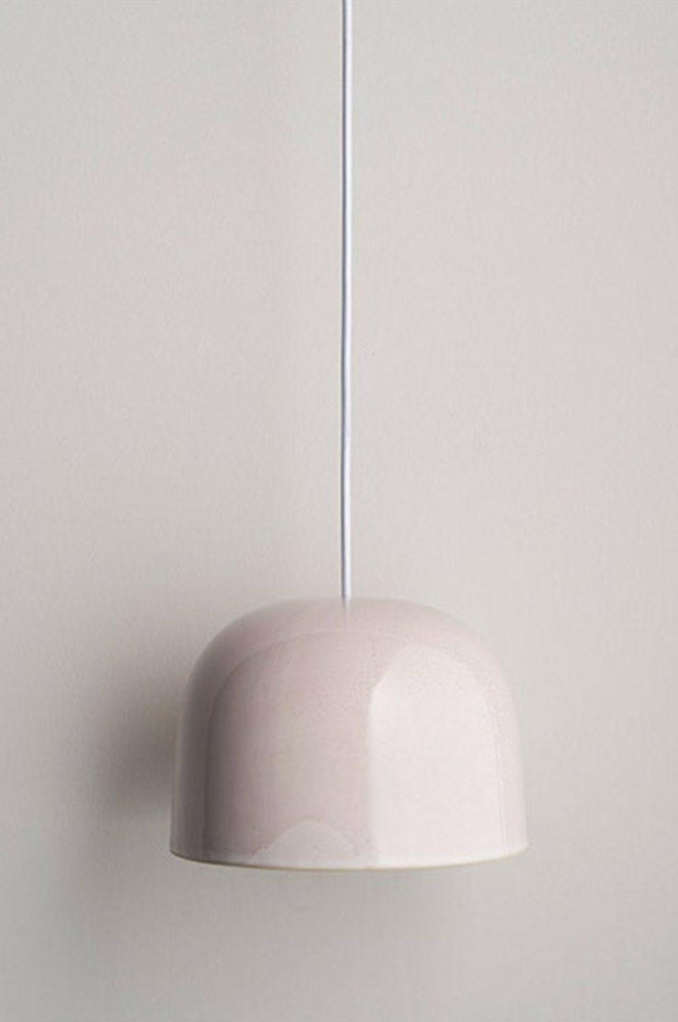 Pink ceramic pendant light against a plain background
