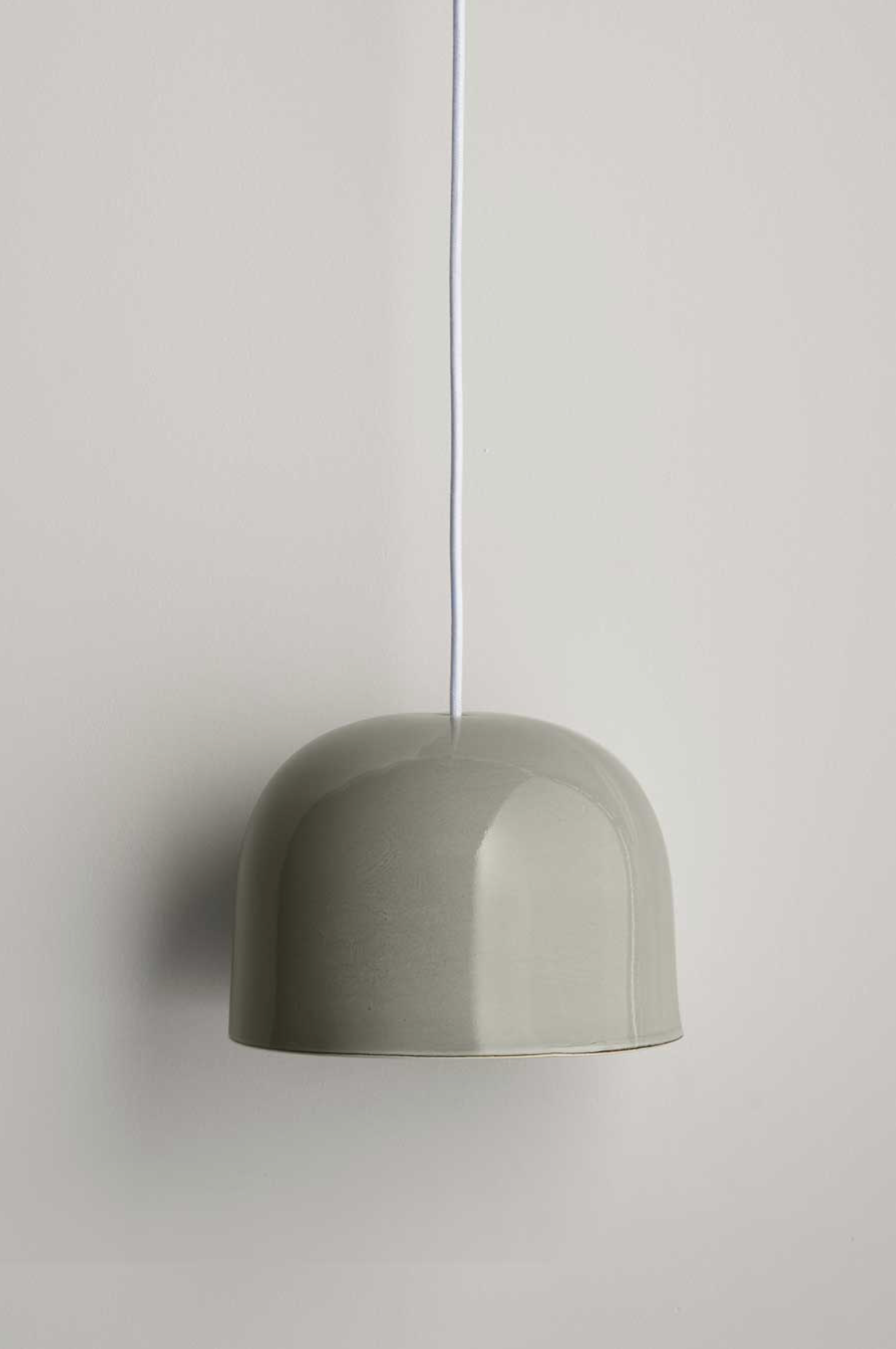 Green ceramic pendant light against a plain background