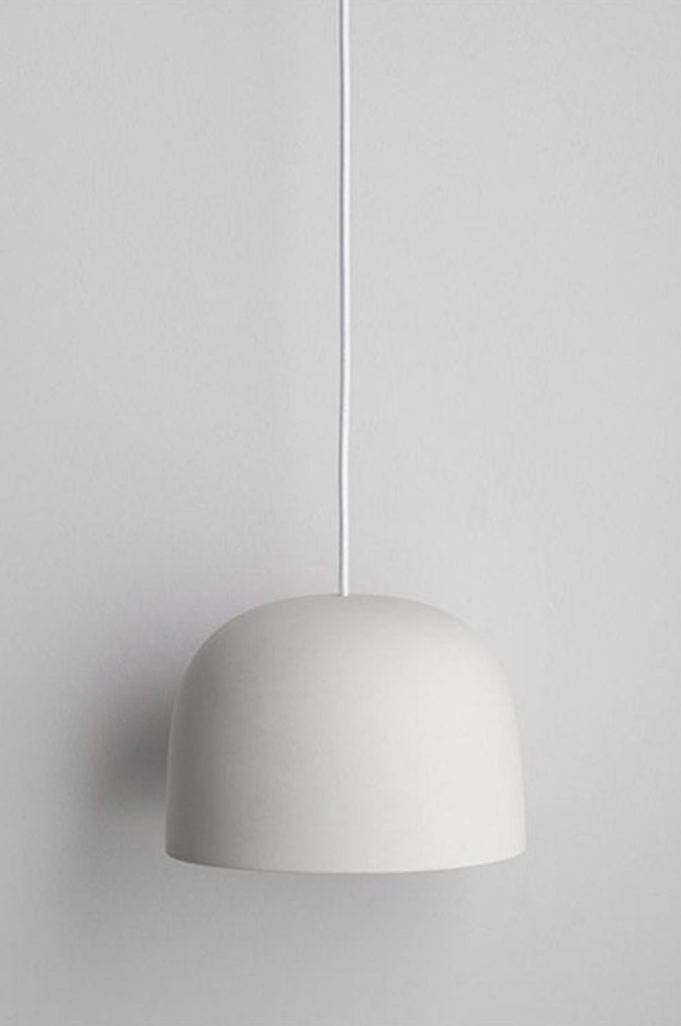 White ceramic pendant light against a gray background