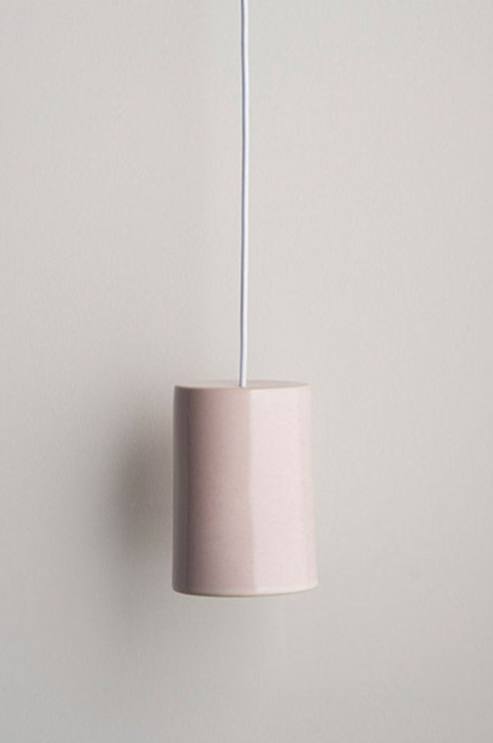Pink ceramic pendant light against a plain background