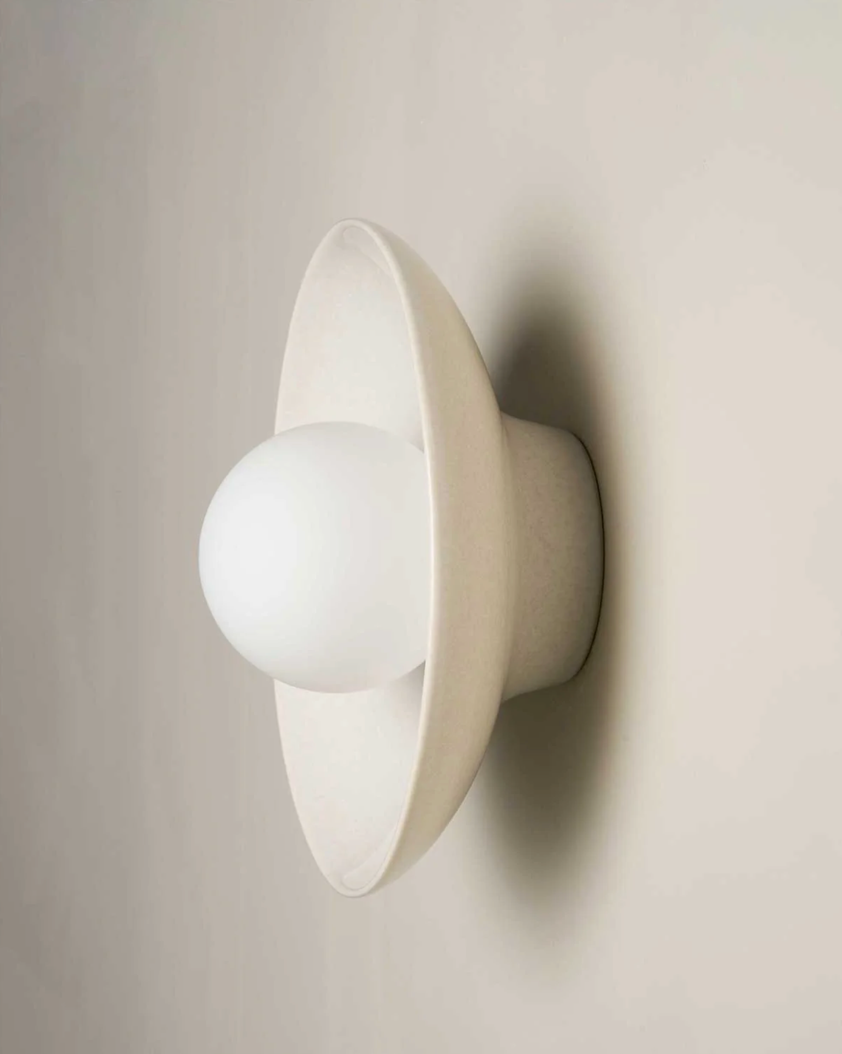 White wall-mounted ceramic wall light fixture on a plain background