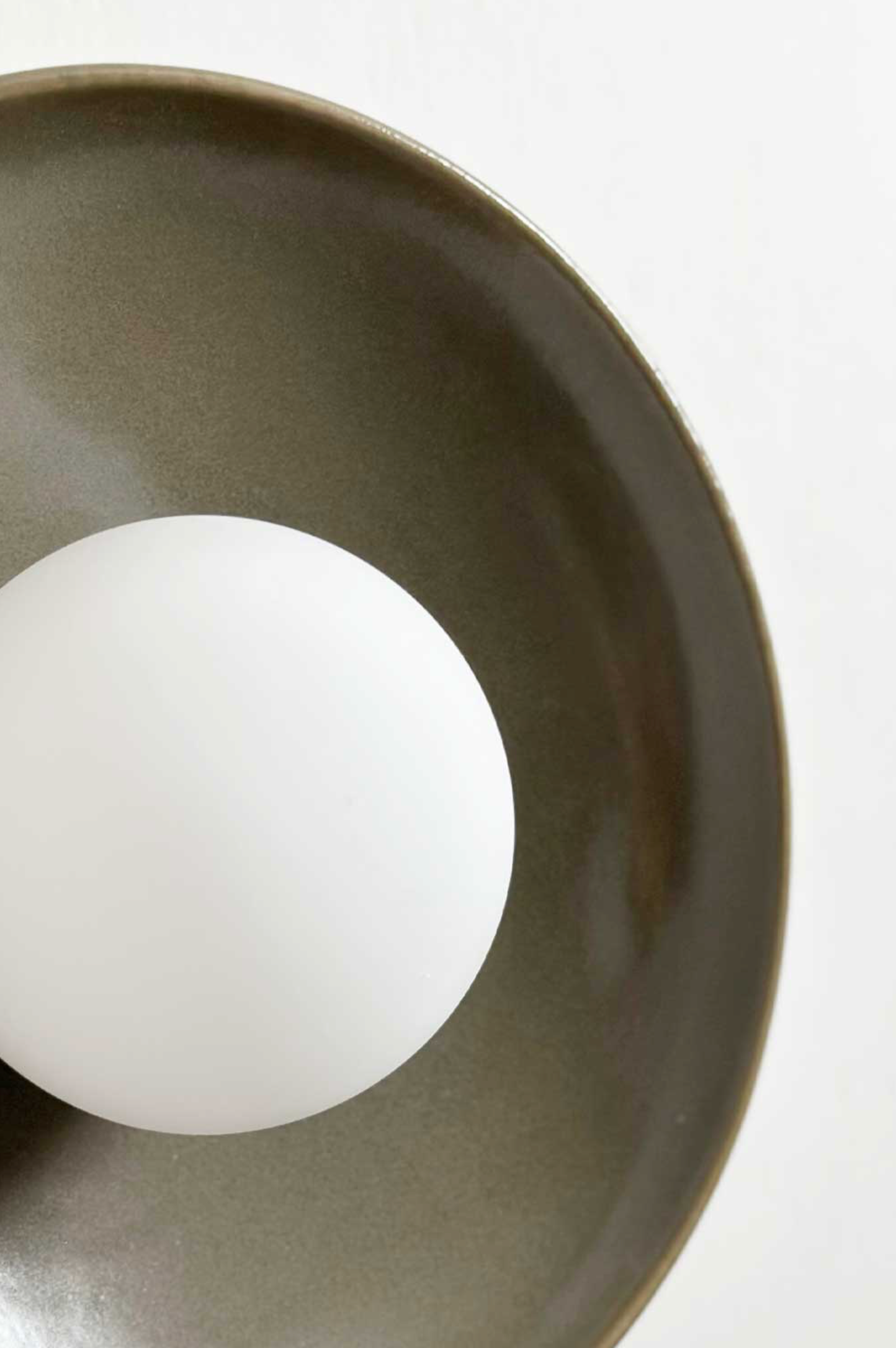 Close-up of a white light bulb inside a ceramic fixture on a white background