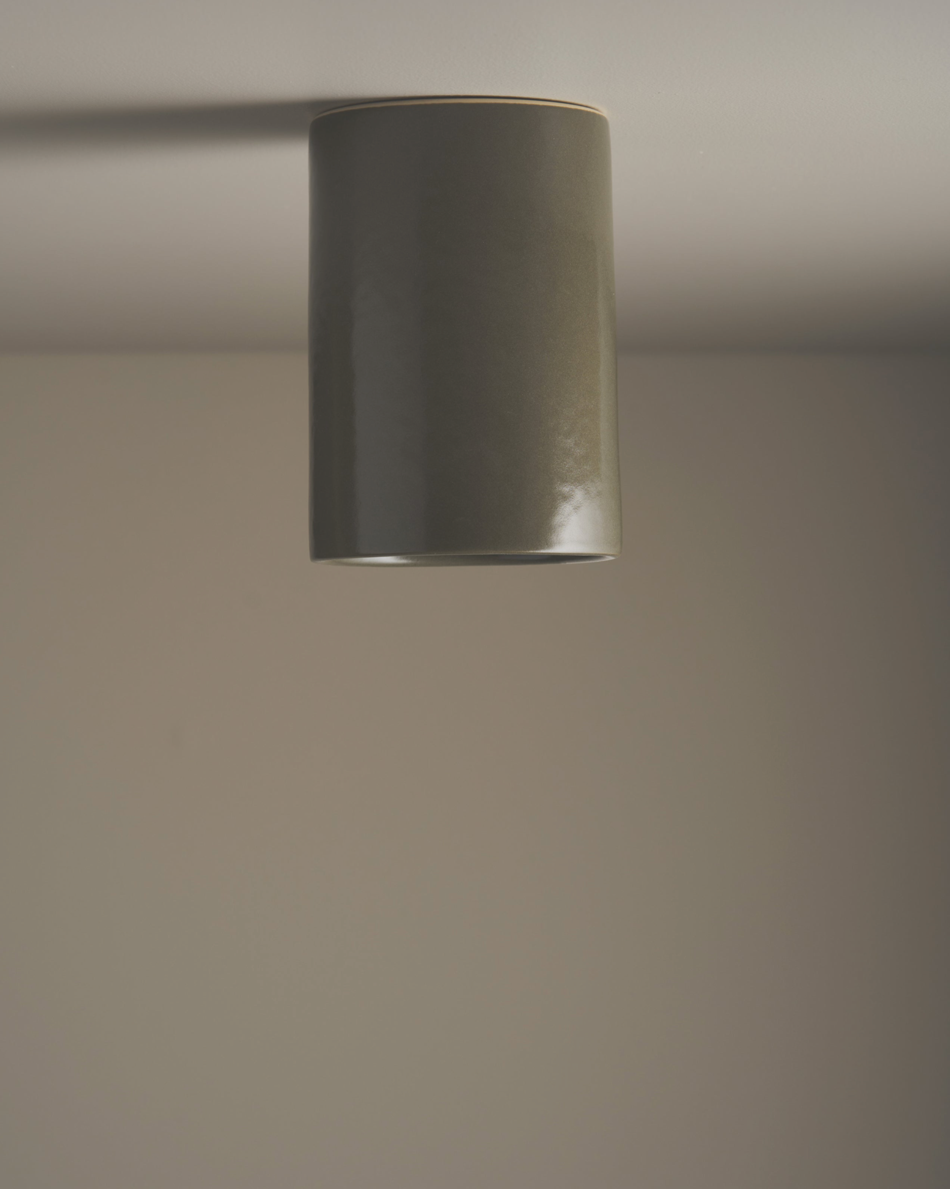 Cylindrical ceramic interior ceiling light fixture on a plain ceiling