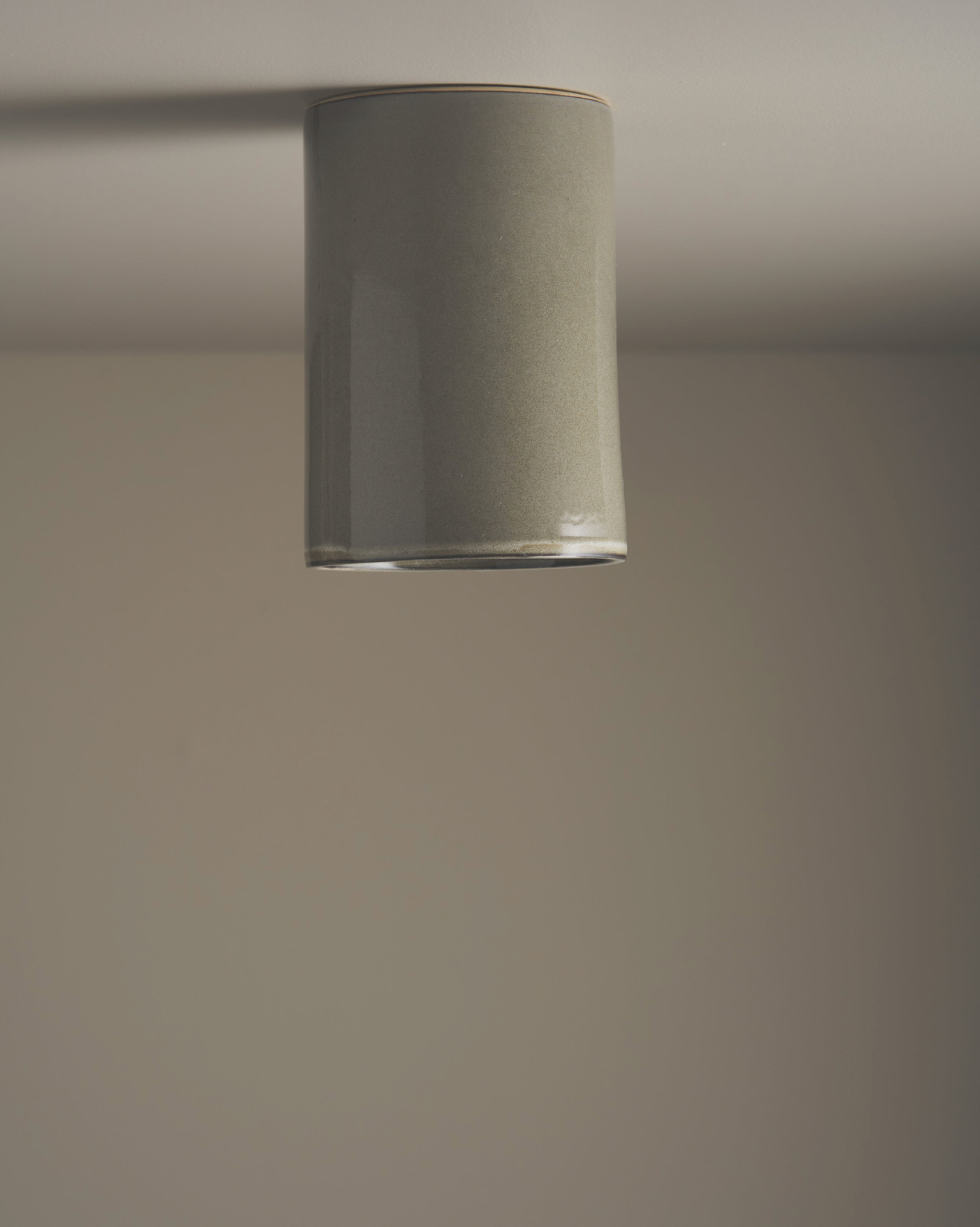Ceramic cylindrical light fixture on a plain wall