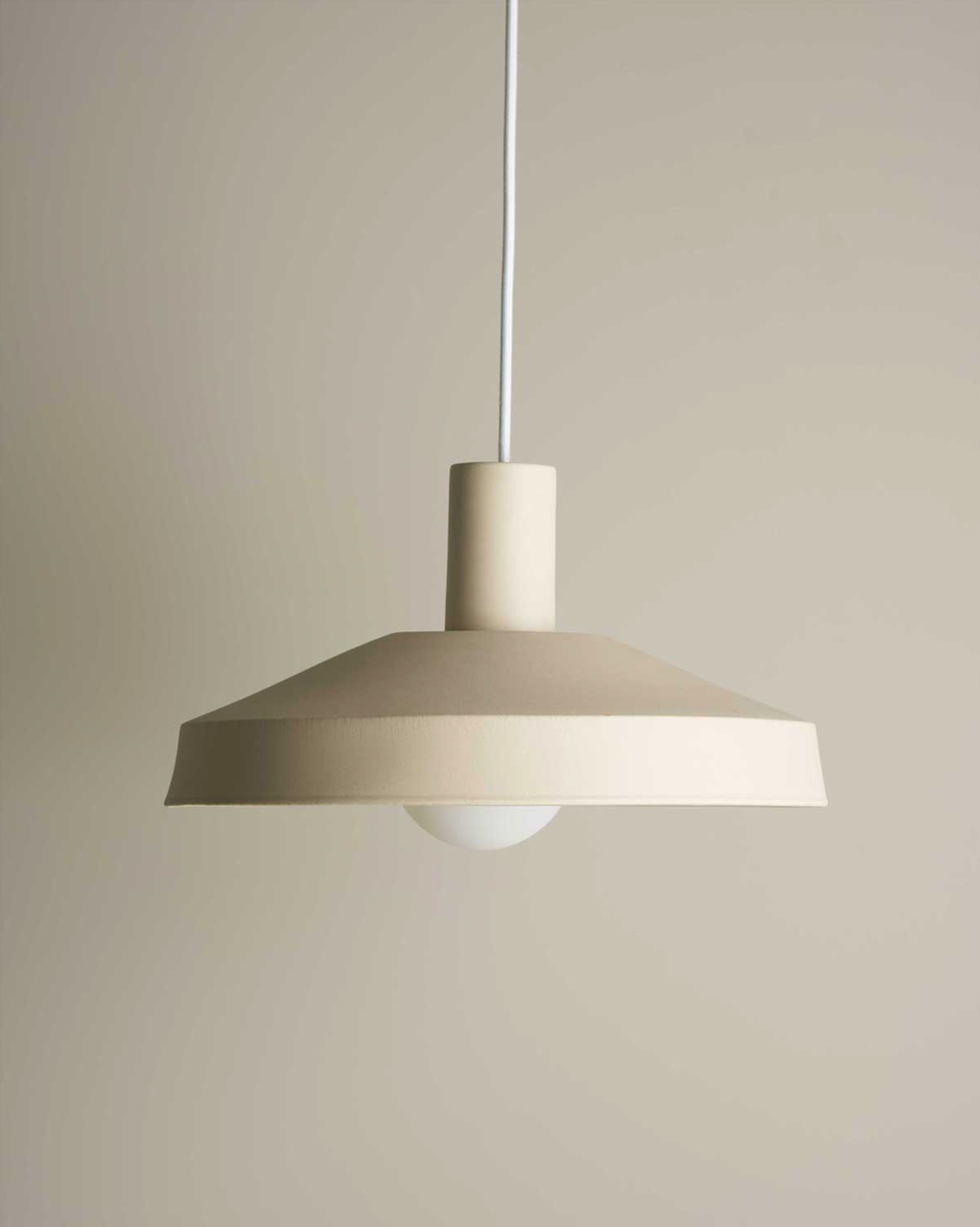 Beige ceramic pendant light against a plain background