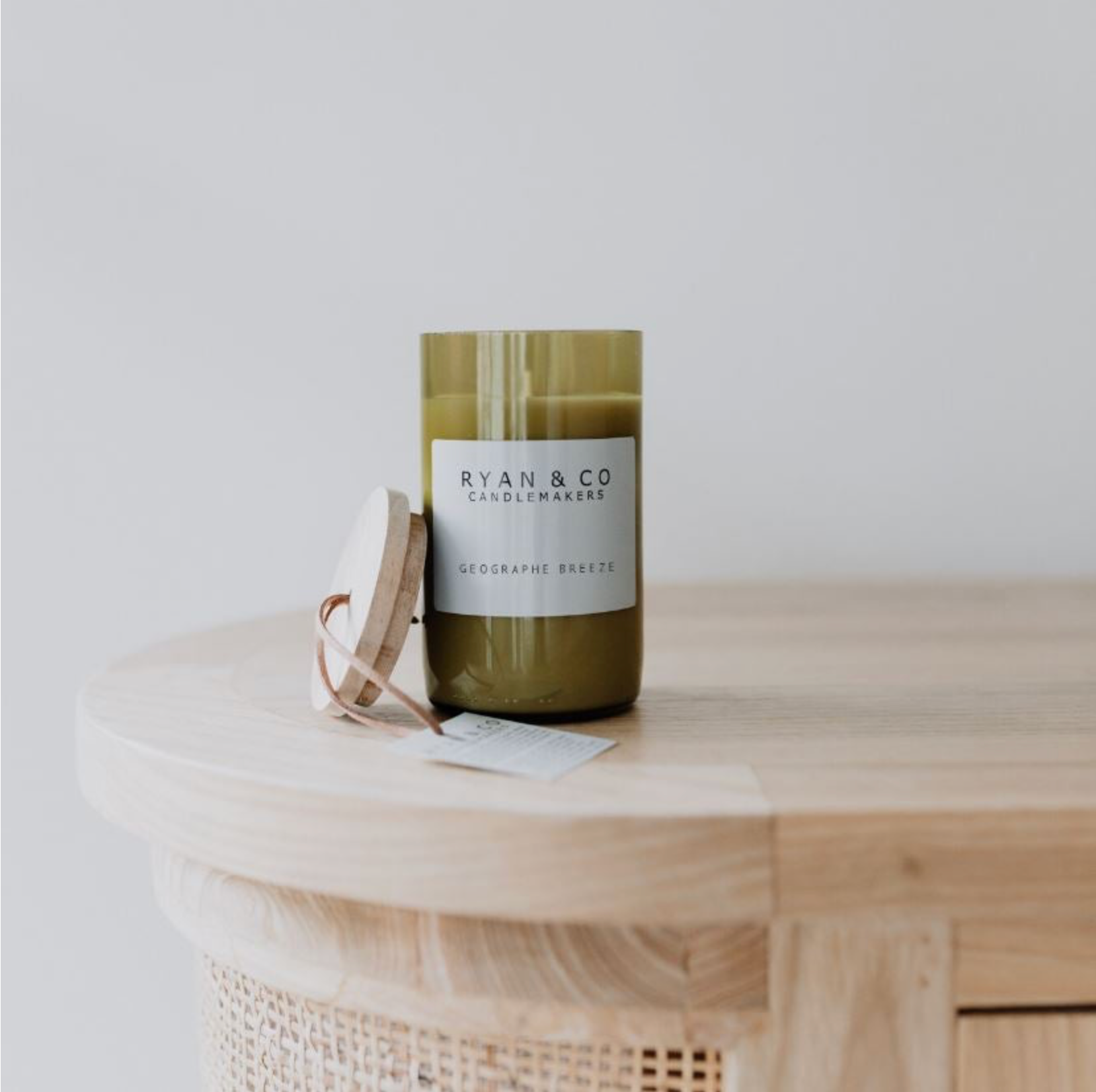 Green candle with a label on a wooden surface