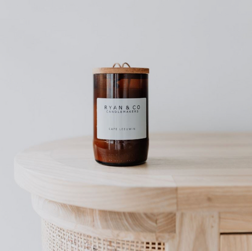 Candle with a label on a wooden surface