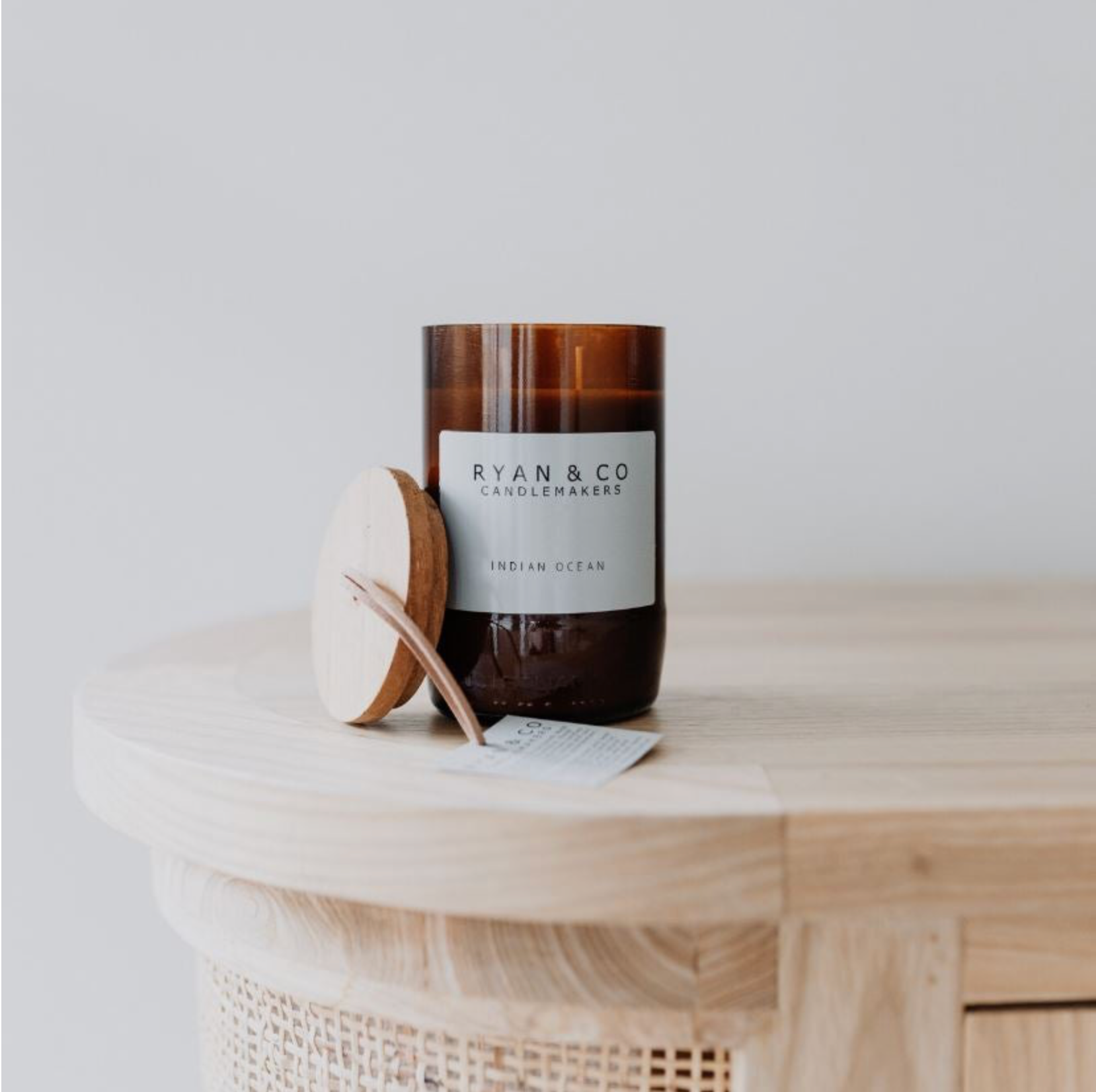 Candle with a label on a wooden surface, featuring 'Ryan & Co Candlemakers'.