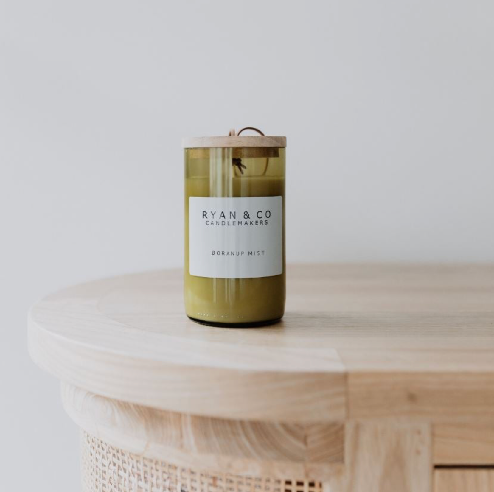 Candle with a label on a wooden surface