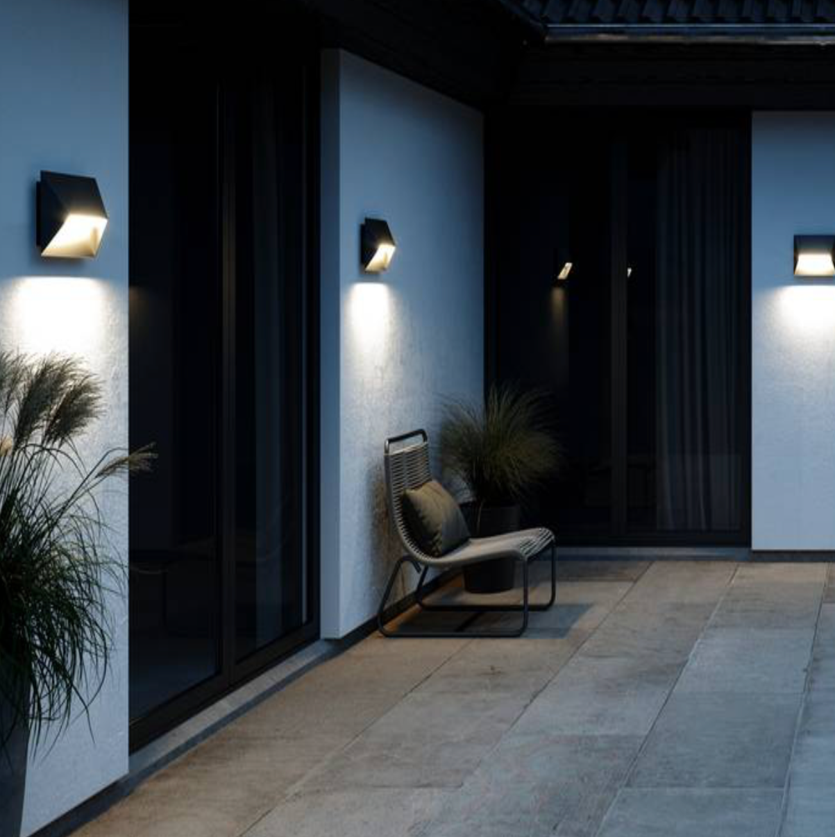 Modern outdoor setting with outdoor wall lights and a chair.