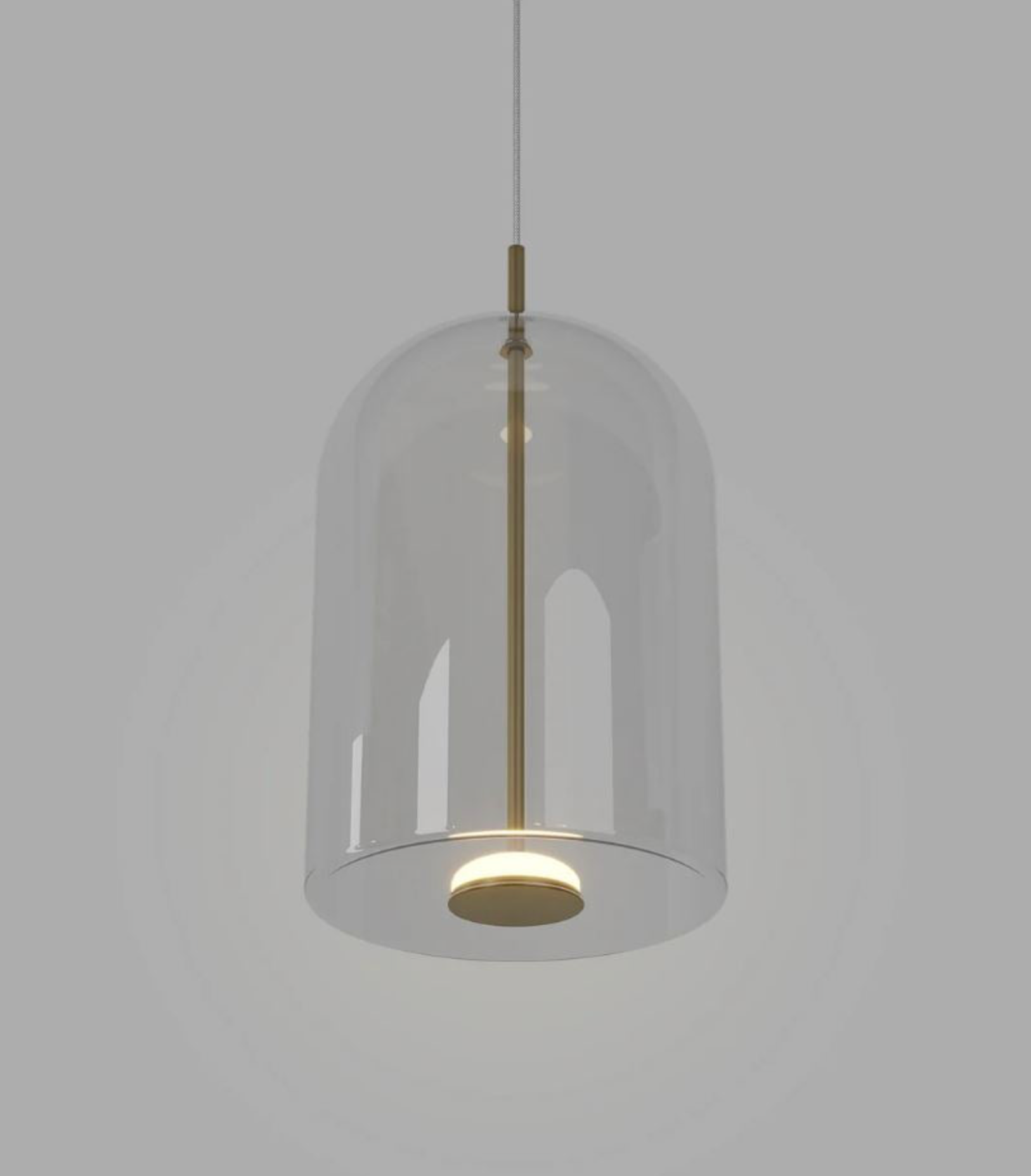 Pendant light with clear glass shade and brass fixture on a gray background