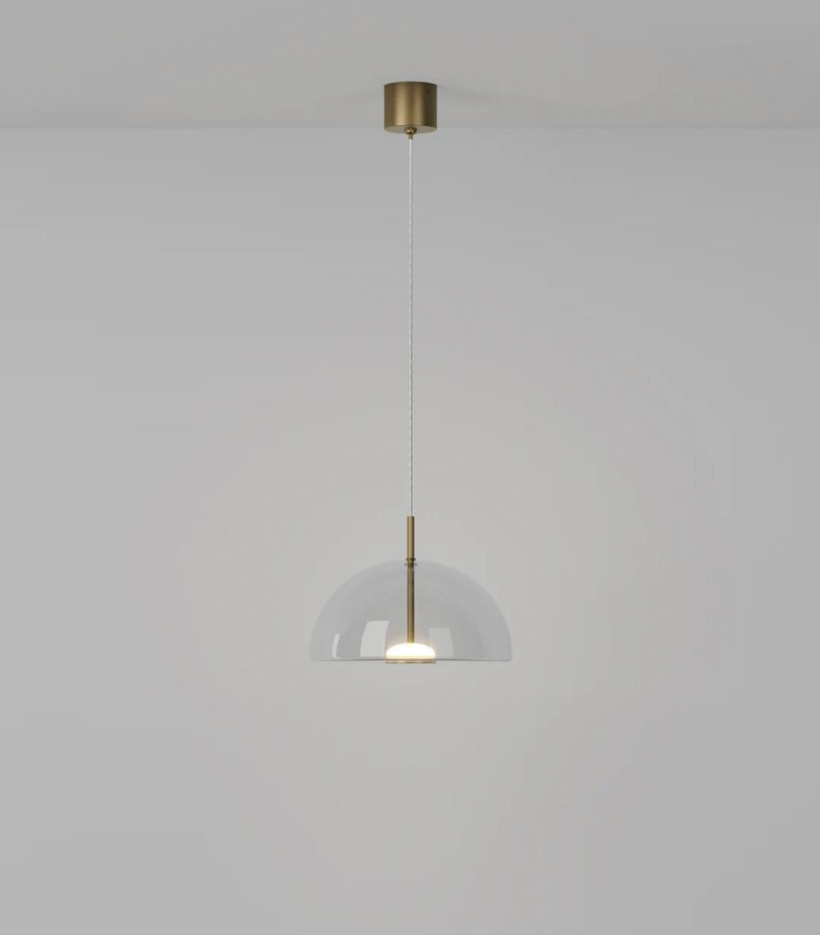 Modern dome pendant light with a glass shade and brass fixture on a plain background