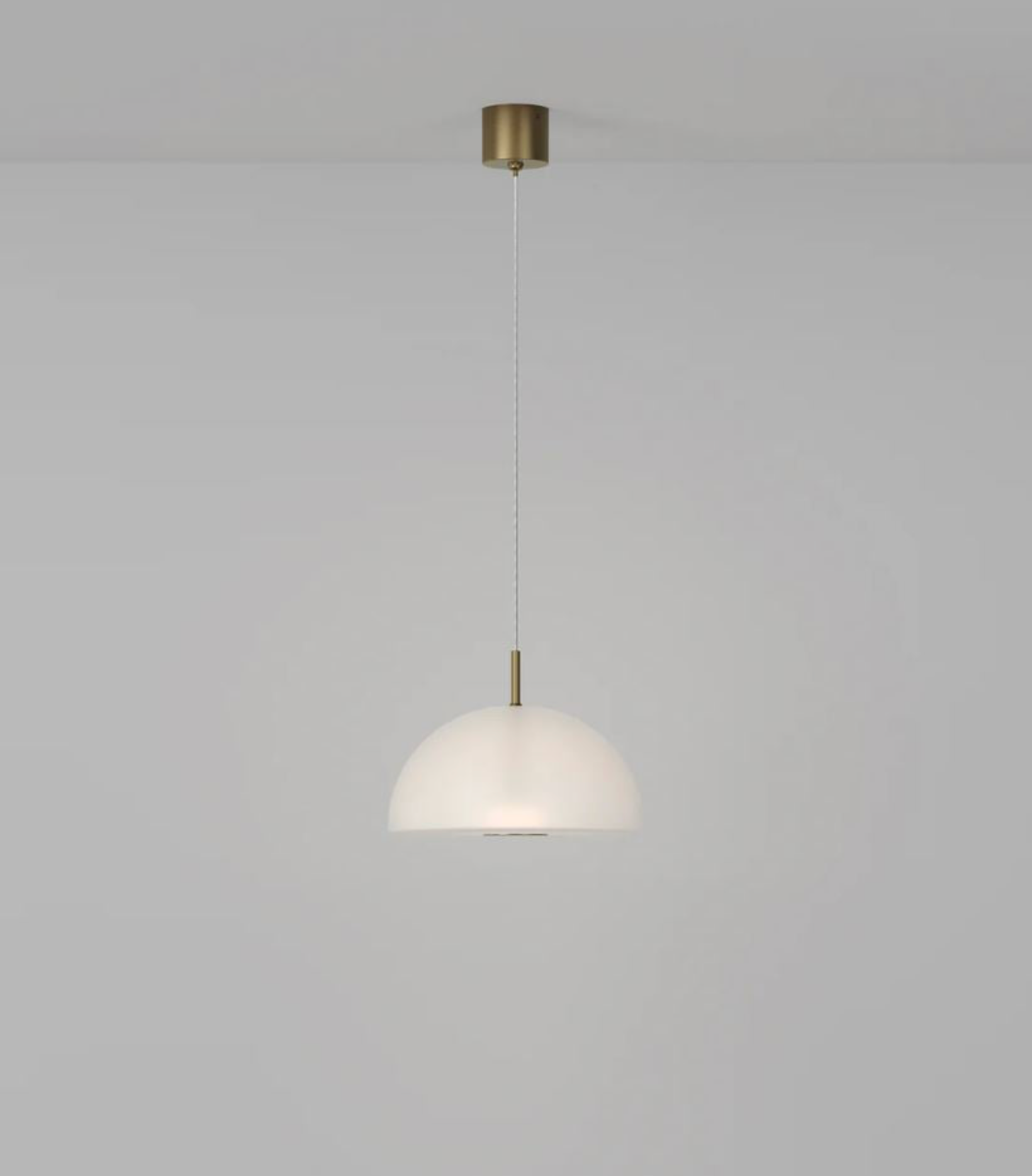 Pendant light with frosted glass dome shade and gold fixture on a grey background