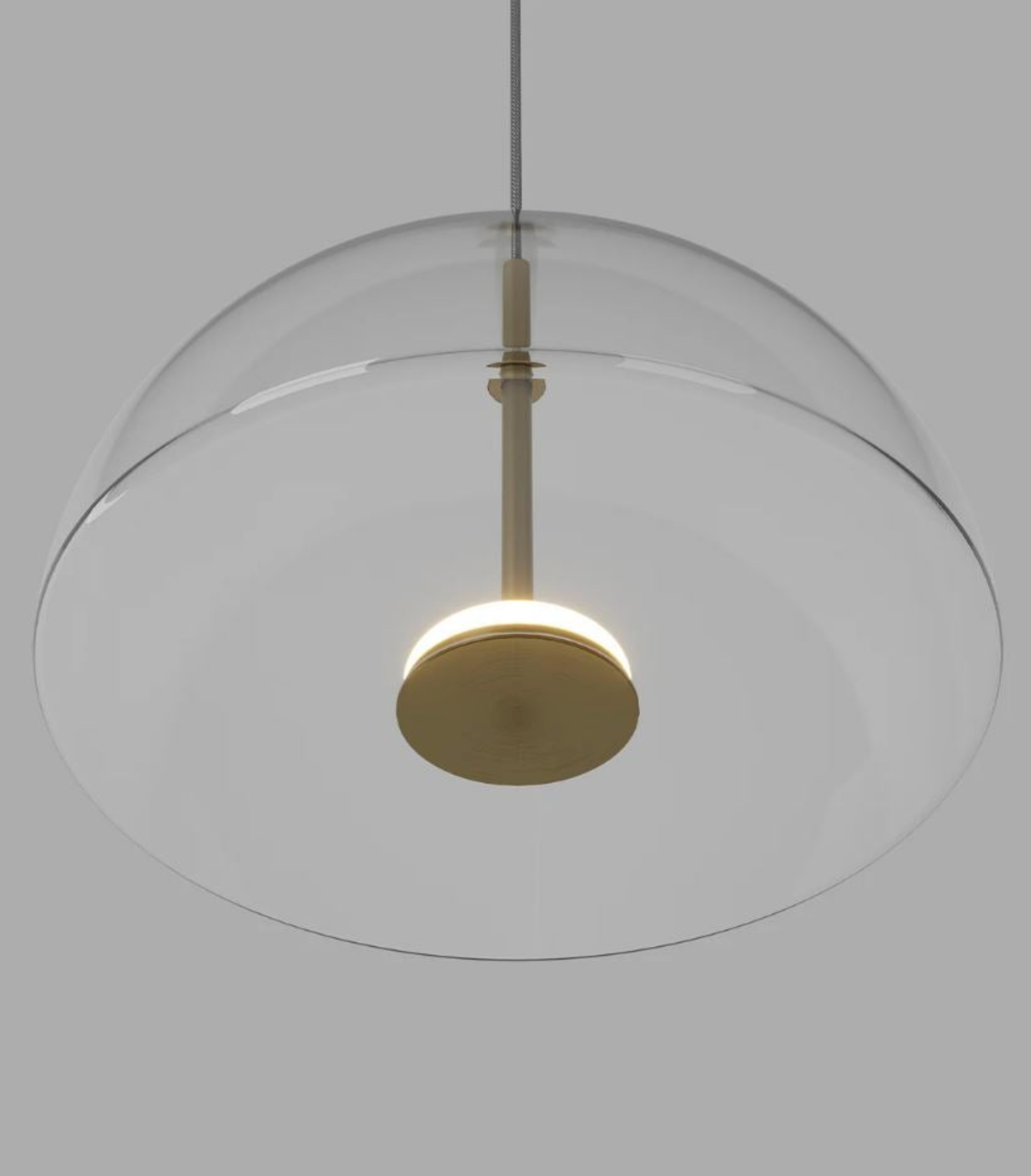Modern pendant light with dome shaped glass shade and gold fixture on a neutral background