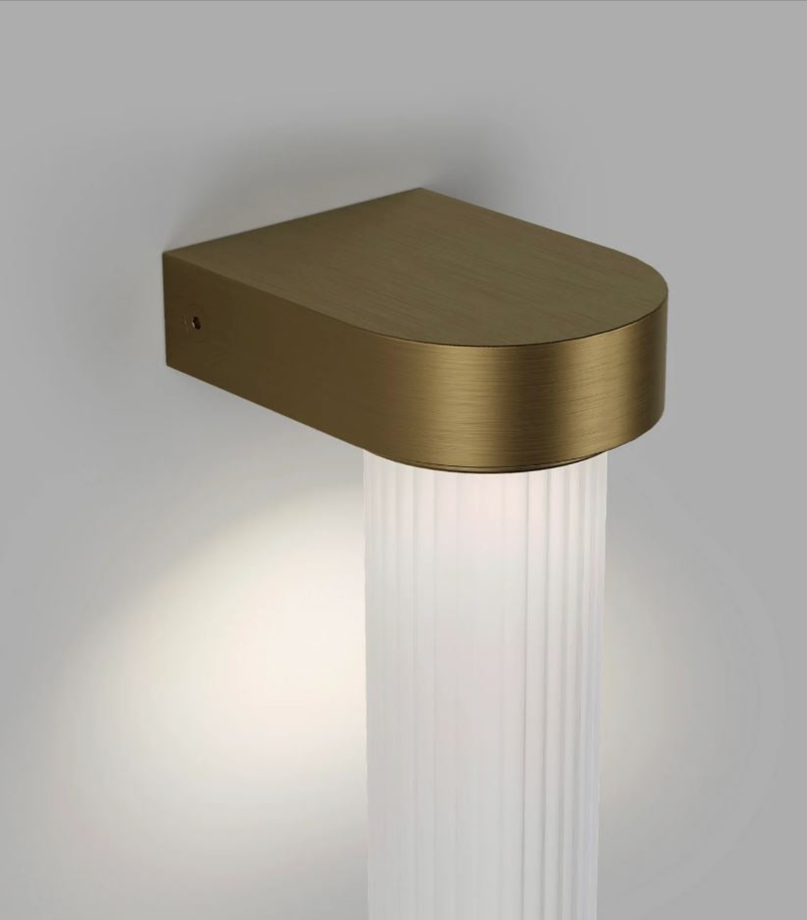 Brass wall-mounted light fixture on a grey background