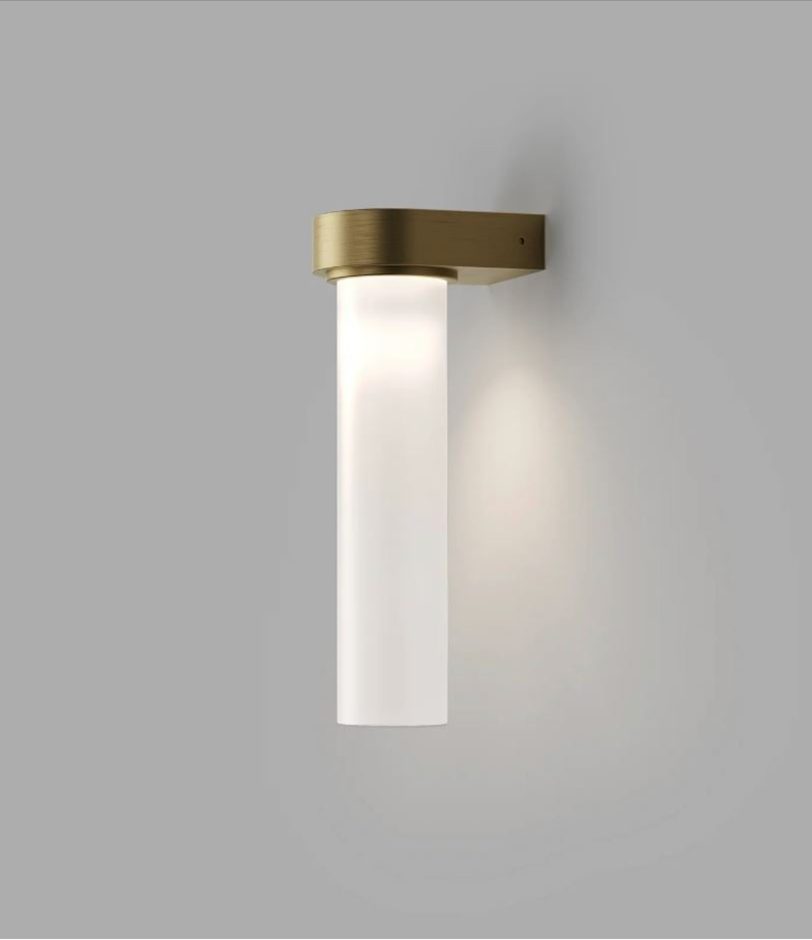 Wall-mounted light fixture with brass finish and white glass on a grey background