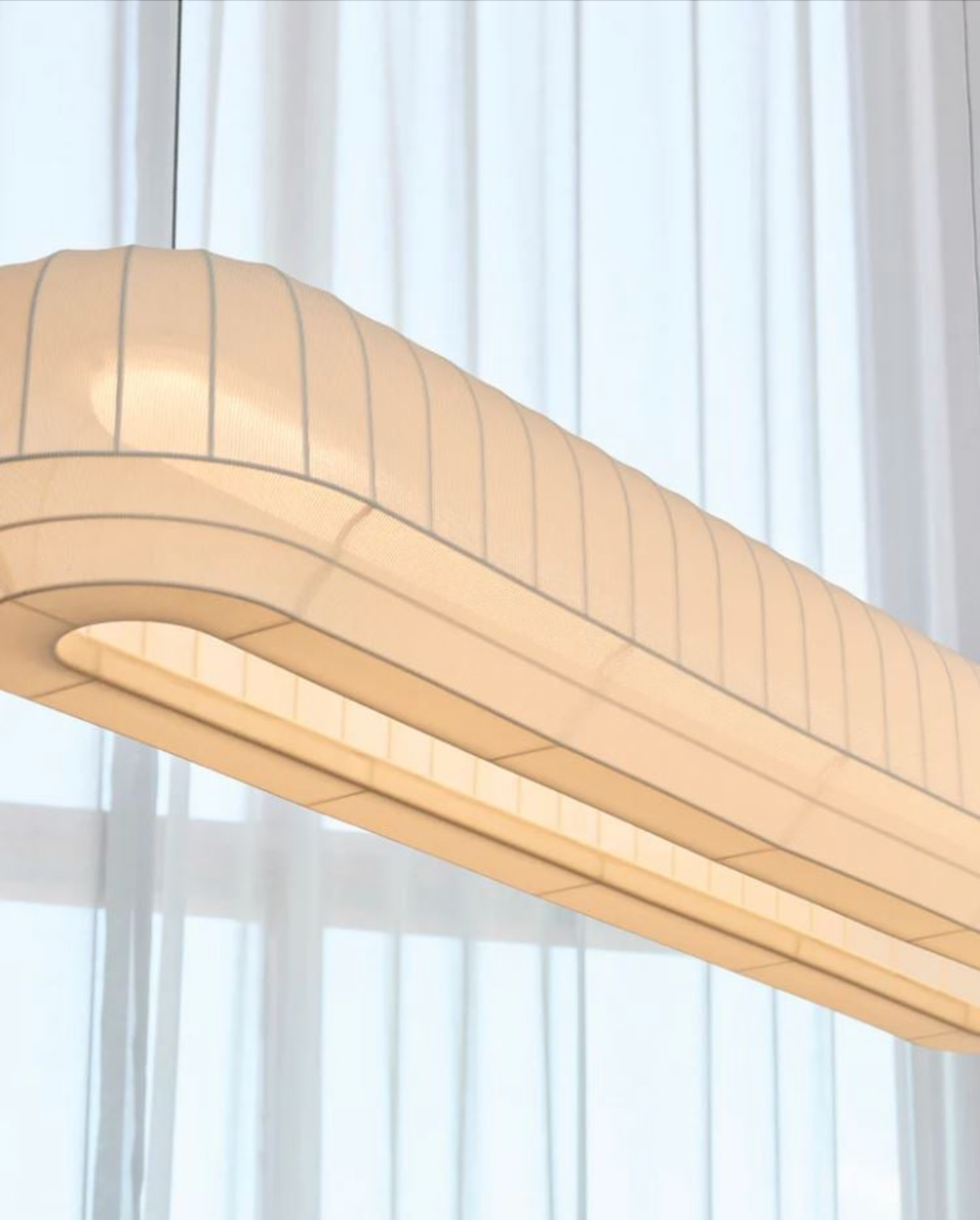 Linear light fixture against a white curtain background