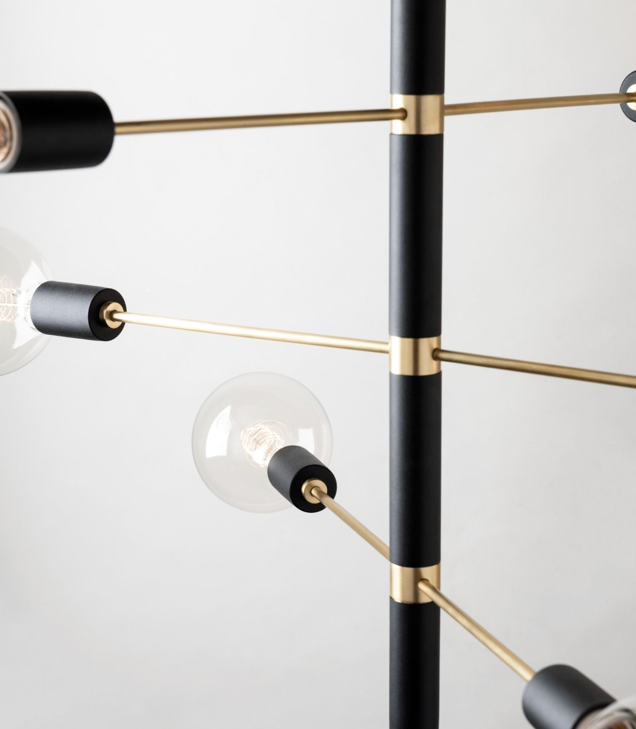 Modern pendant light fixture with black and gold design on a white background