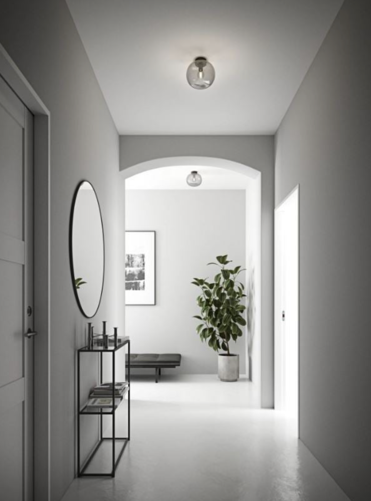 Modern hallway with a glass ceiling light, mirror, plant, and framed picture on a white wall.