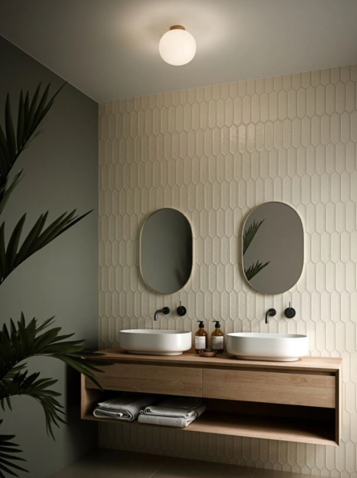 Modern bathroom with glass ceiling light, two oval mirrors, a wooden vanity, and white tiles on the wall.