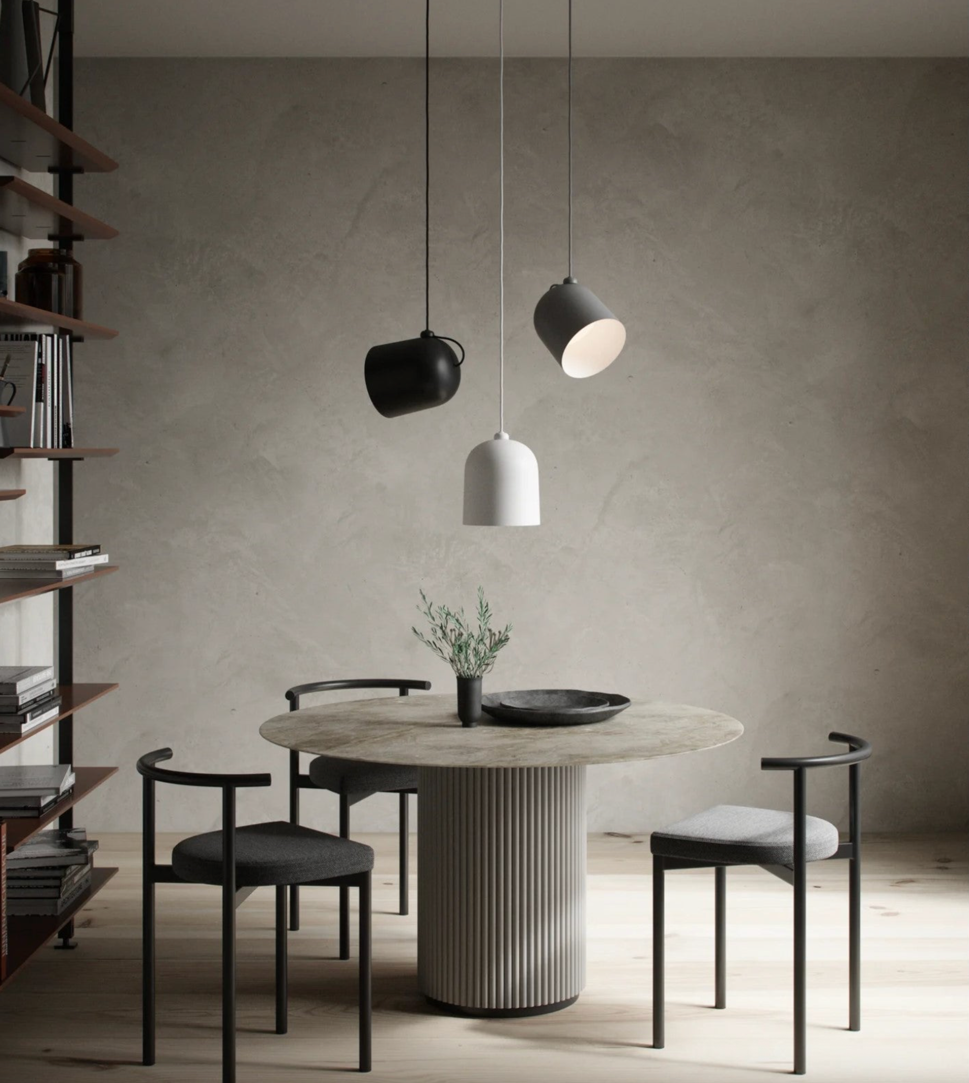 Modern dining area with a round table and chairs, featuring pendant lights.