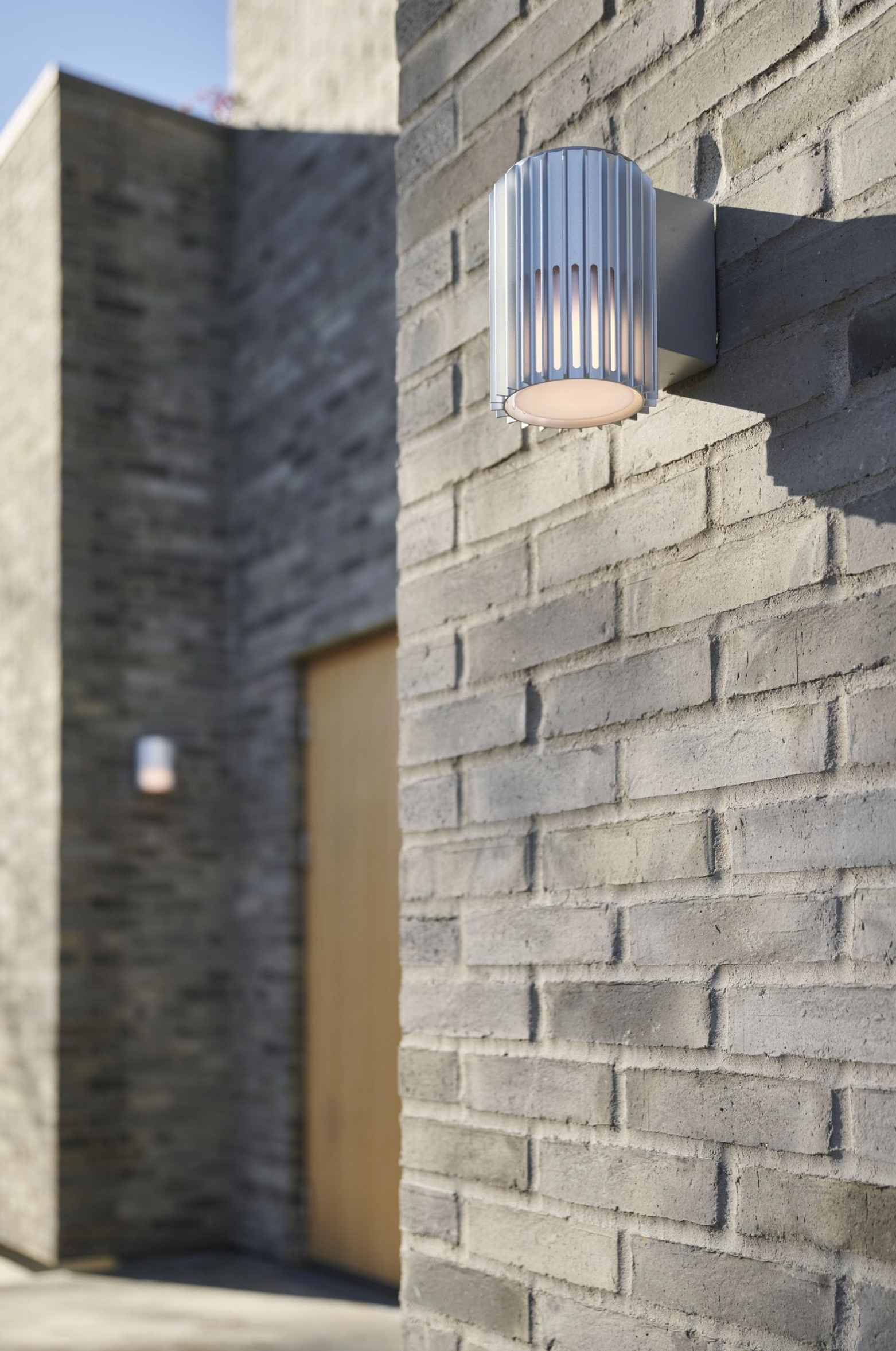 Modern outdoor wall light fixture on a brick wall