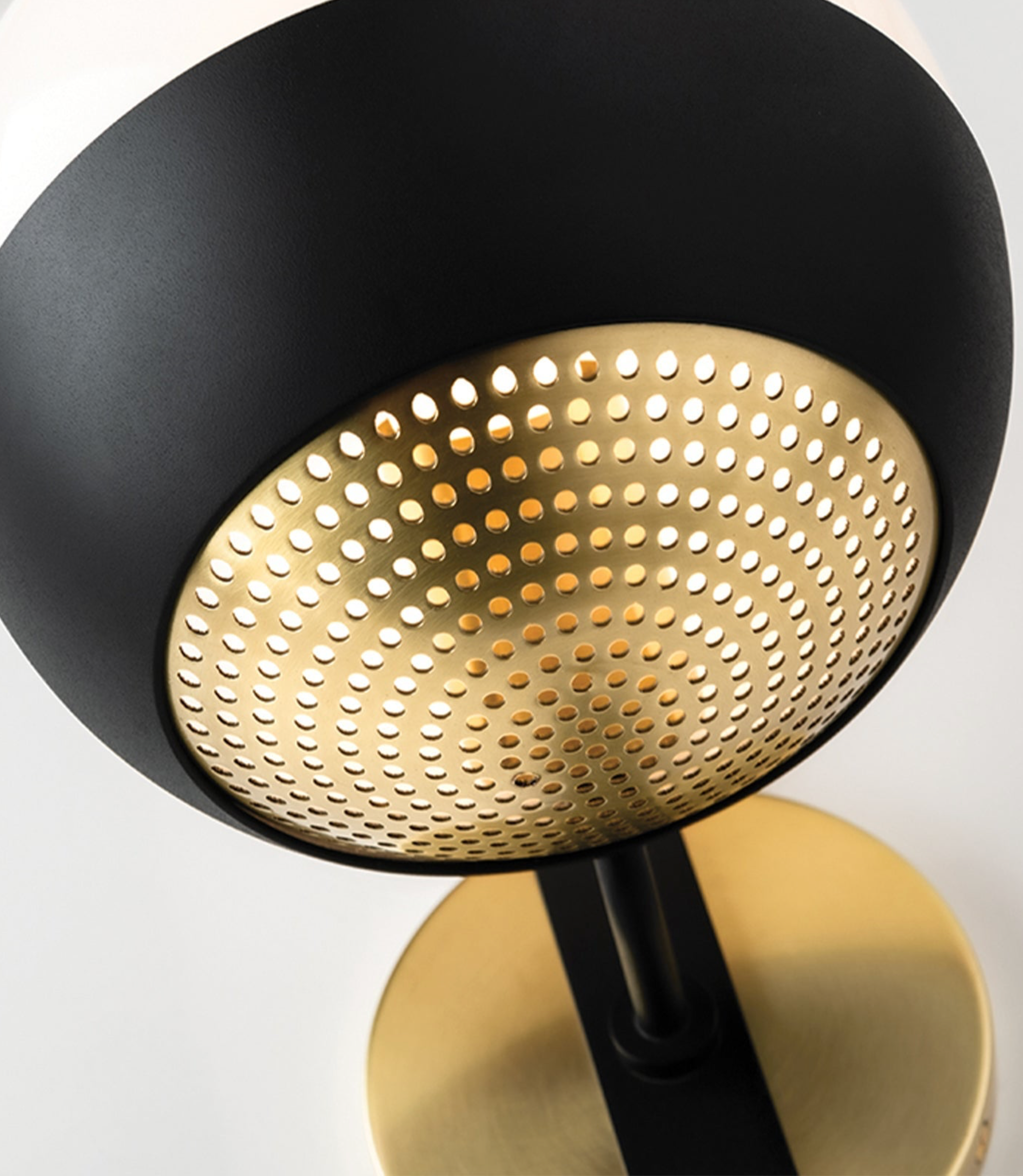 Modern wall light fixture with black and gold design on a white background