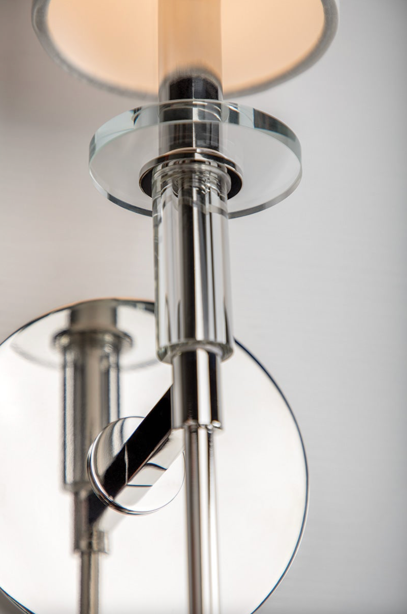 Close-up of a modern wall light fixture with metallic finish and glass shade.