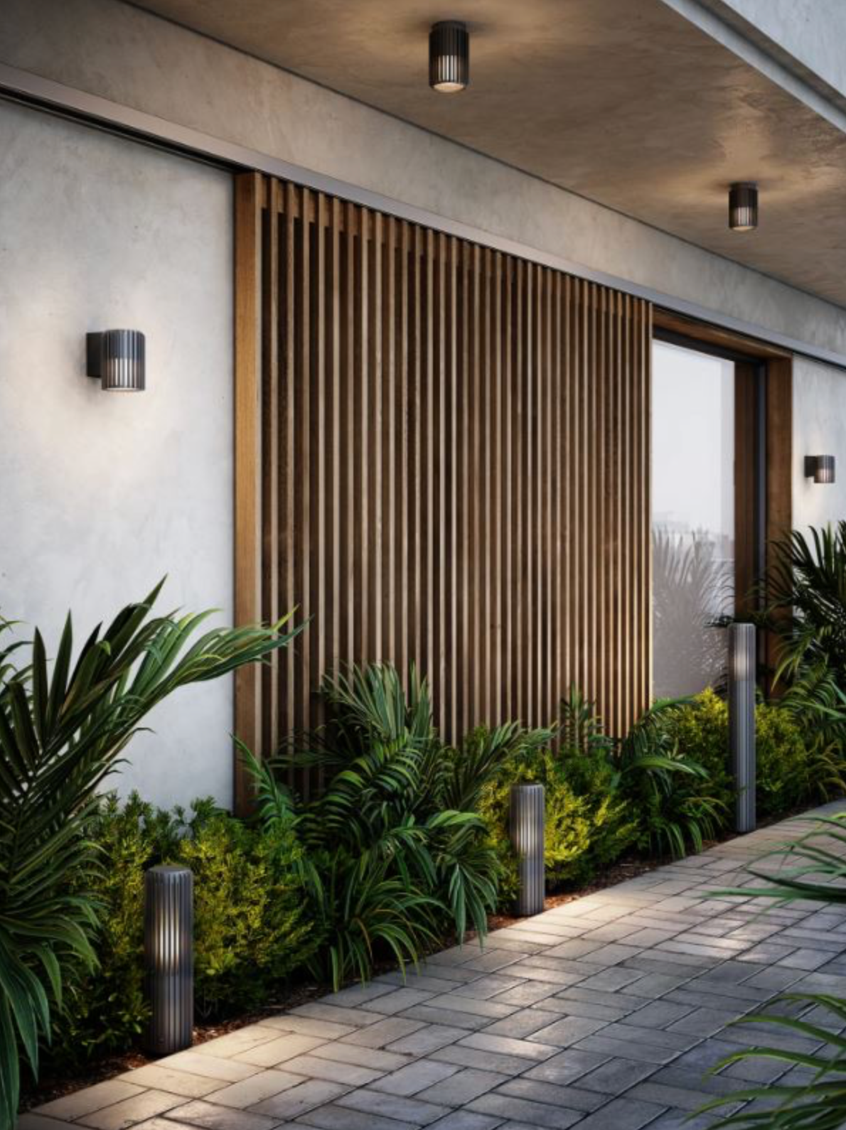 Modern outdoor setting with outdoor ceiling and wall lights, a wooden slat wall, plants, and a paved walkway.