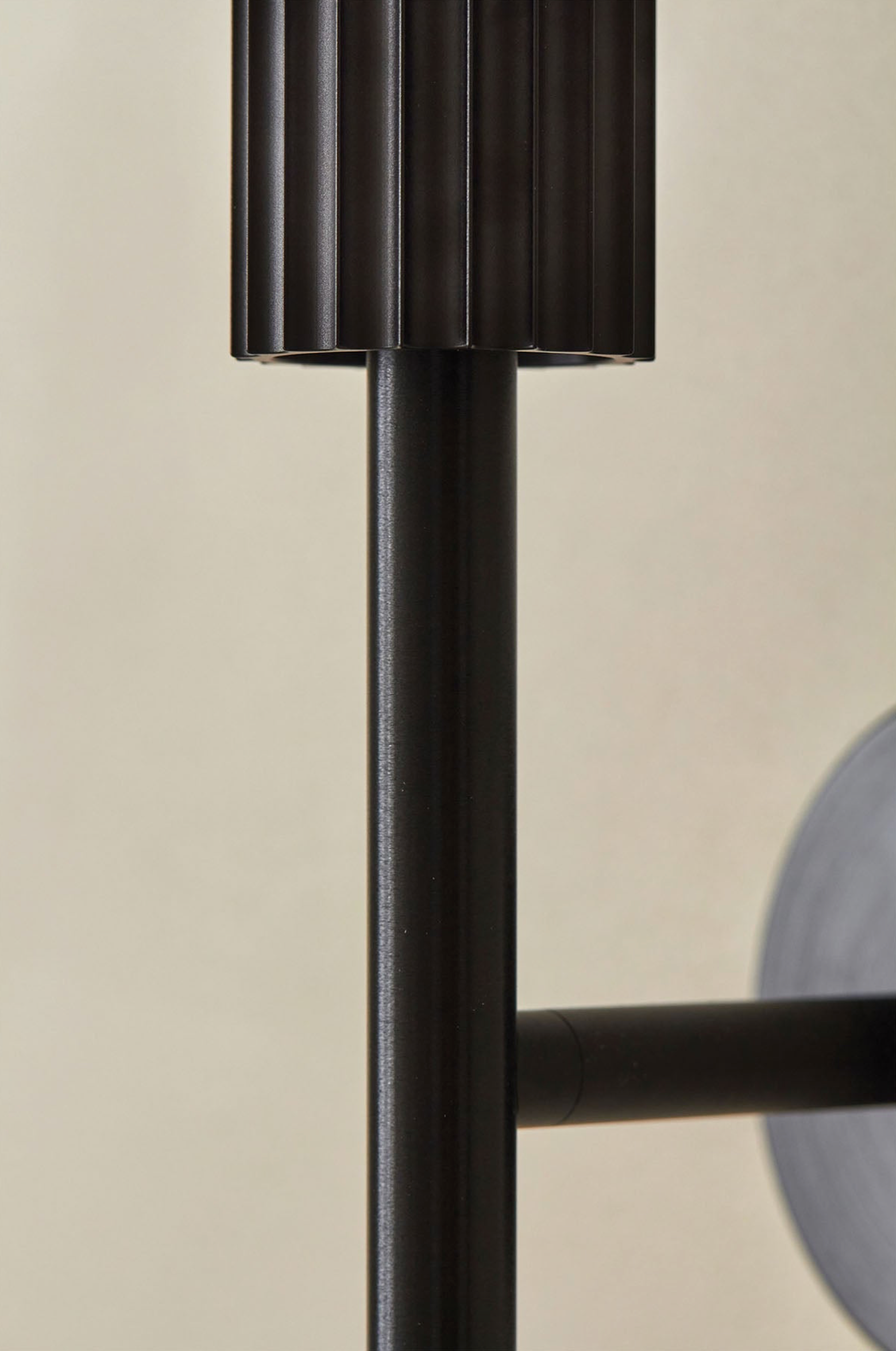 Close-up of a black metal indoor light fixture on a beige background