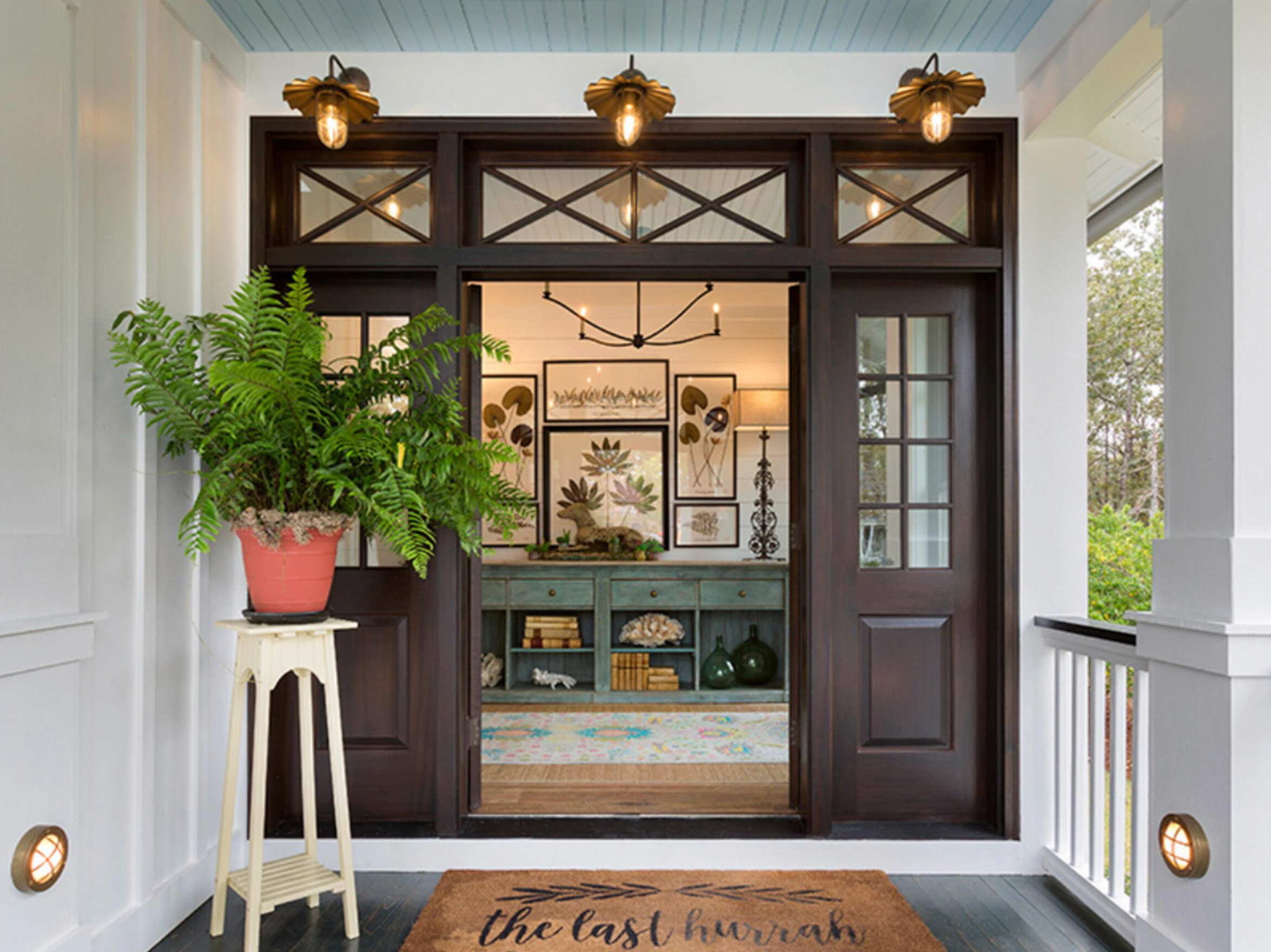 Front door of a house with decorative outdoor lighting and plants