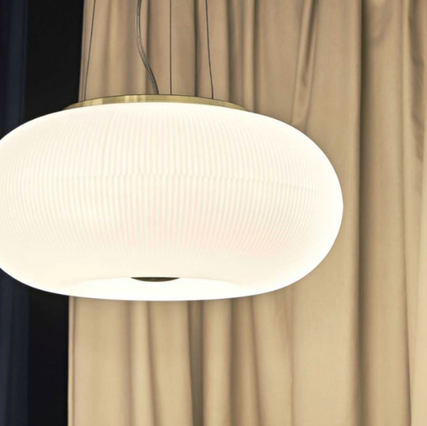 White pendant light against a beige curtain background