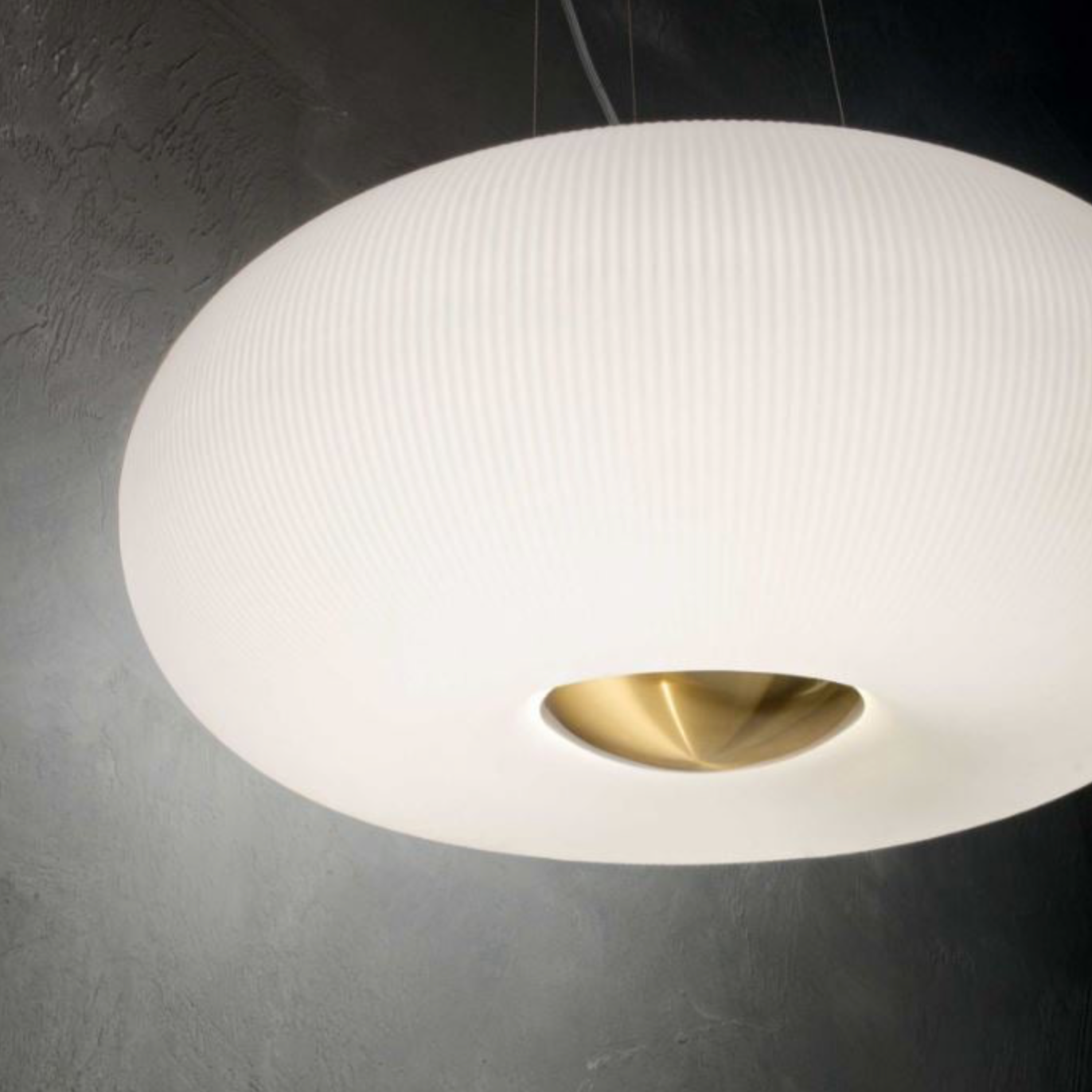 White pendant light with gold interior on a dark background