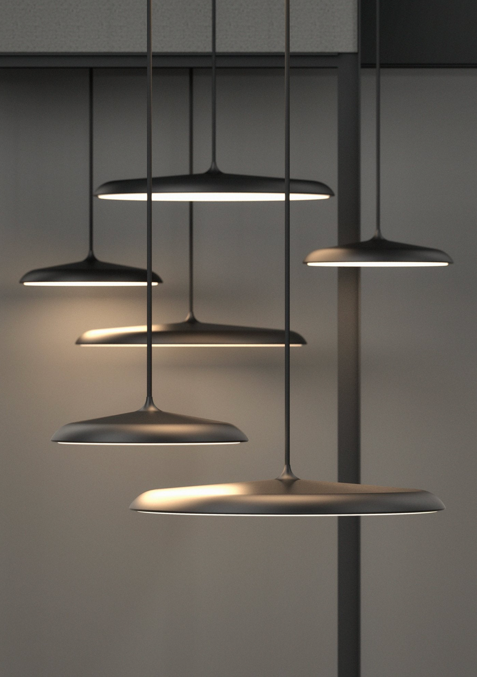 Set of modern pendant lights hanging against a neutral background