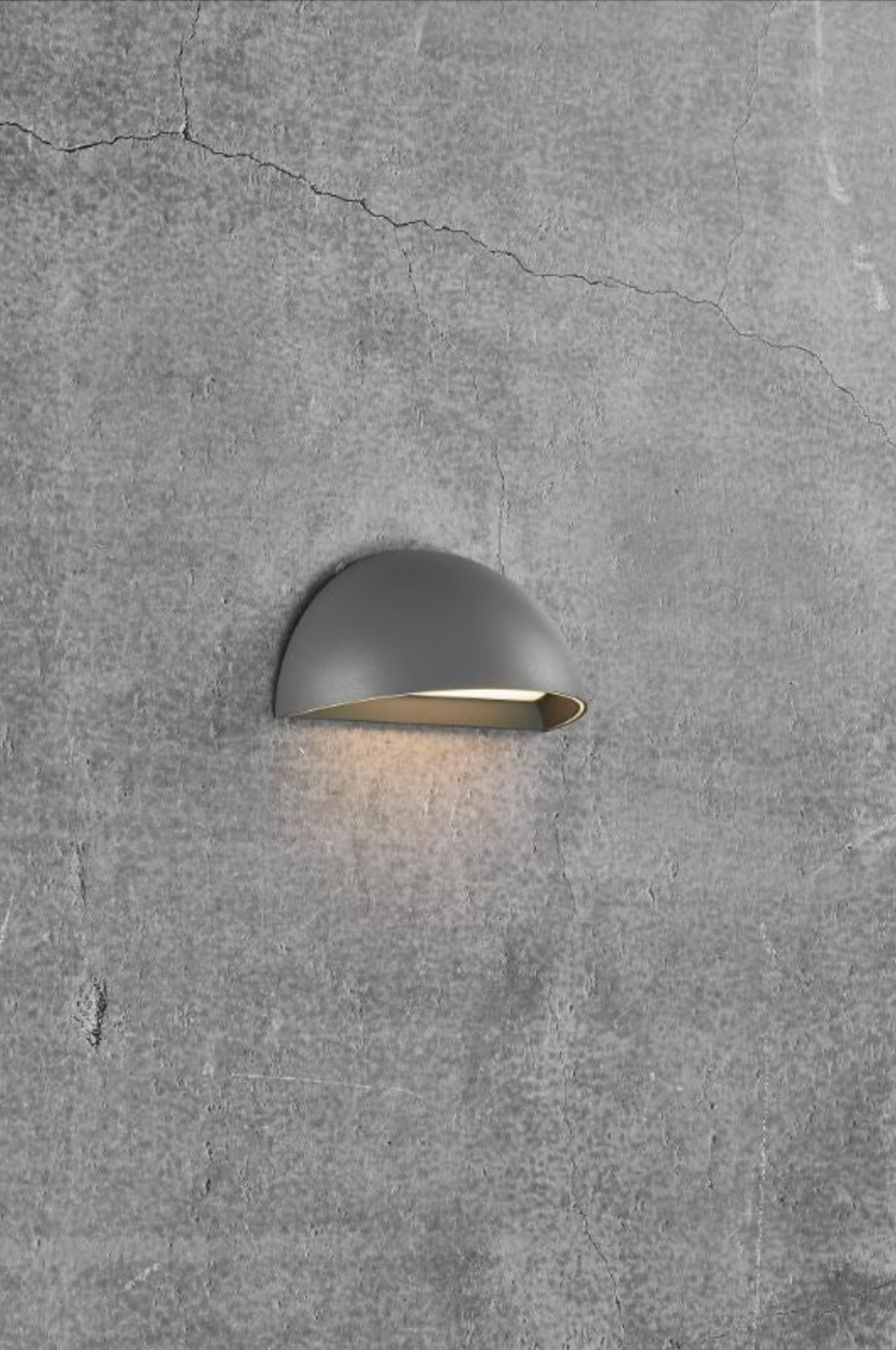 Wall-mounted outdoor light fixture on a textured gray wall