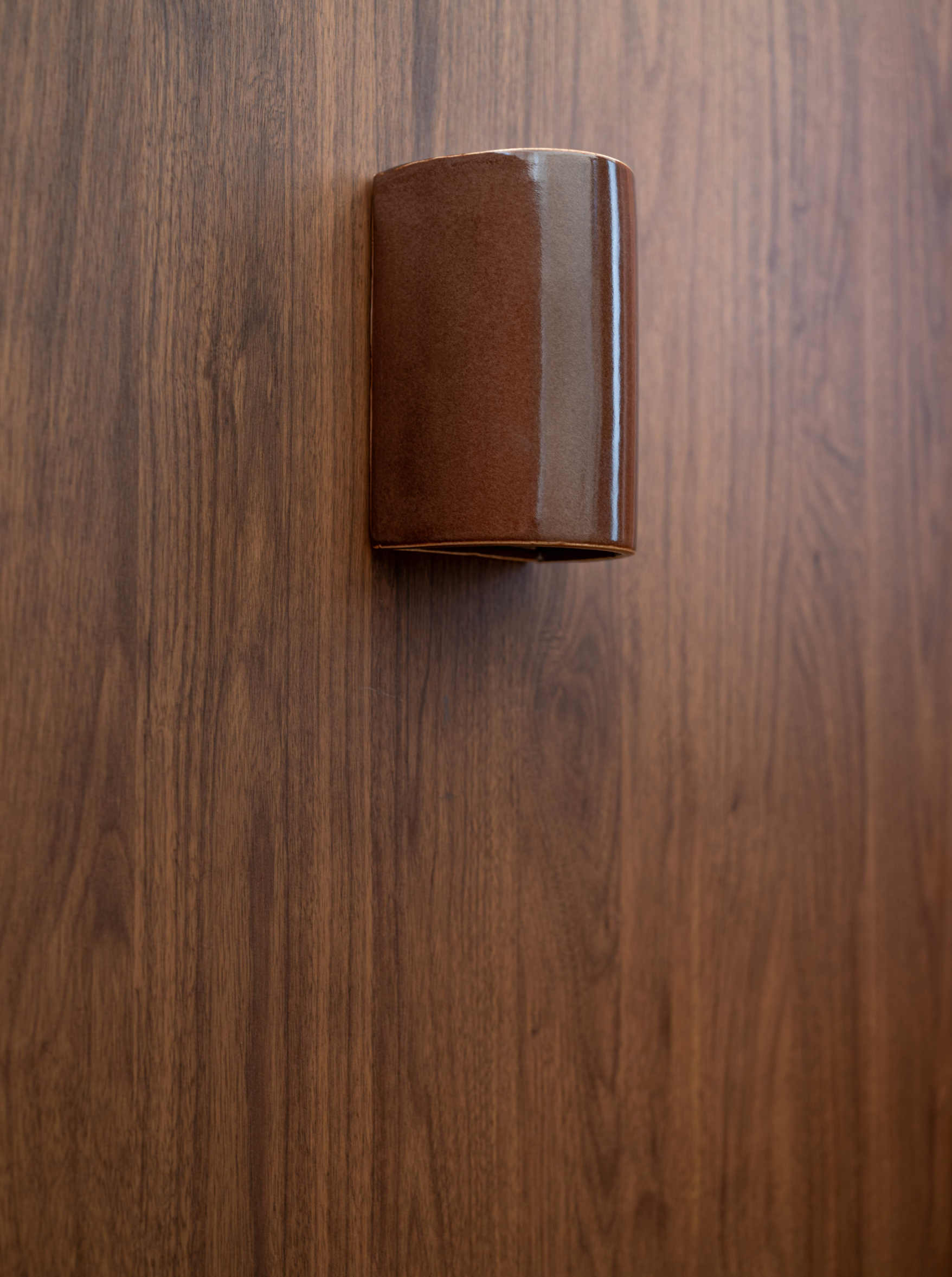 Brown glazed outdoor wall light on a wooden surface