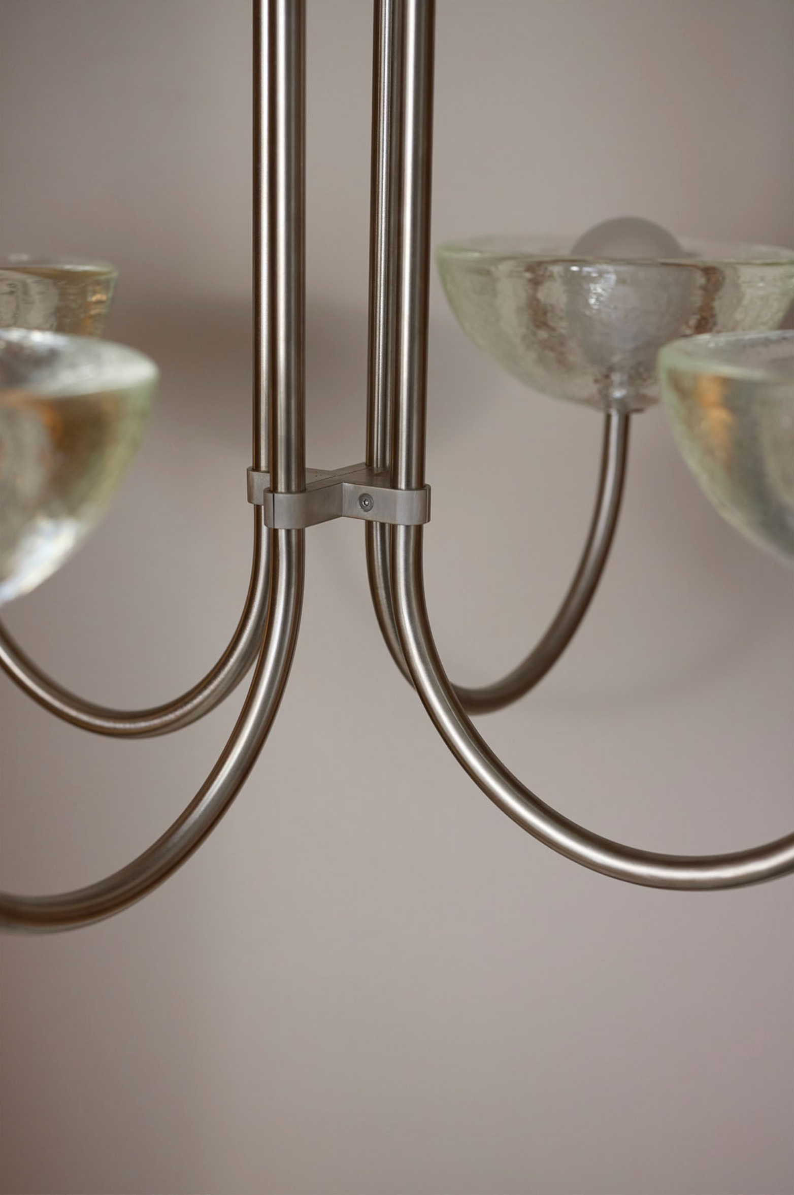 Close-up of a chandelier with glass shades against a neutral background