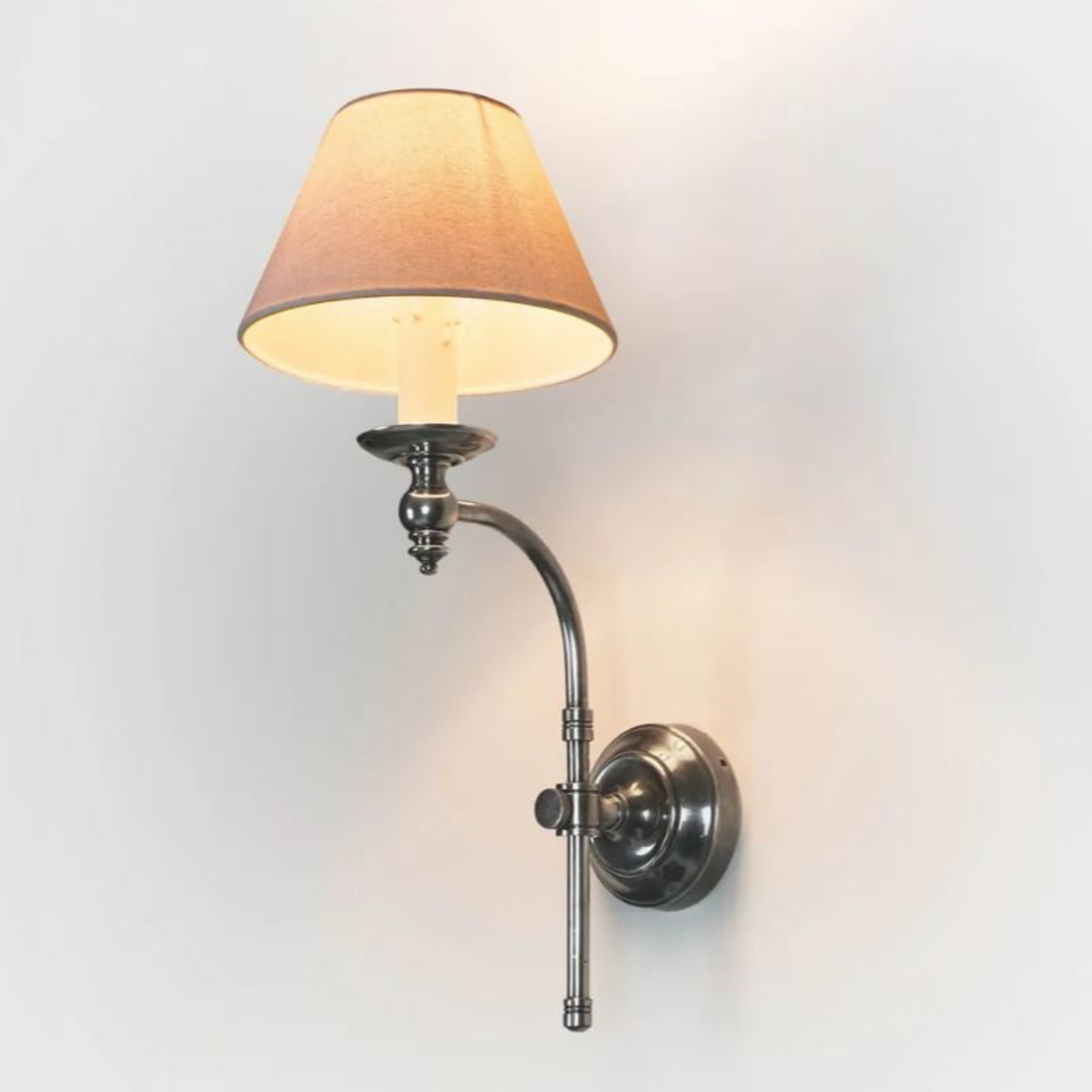 Wall-mounted lamp with a beige shade on a light gray background
