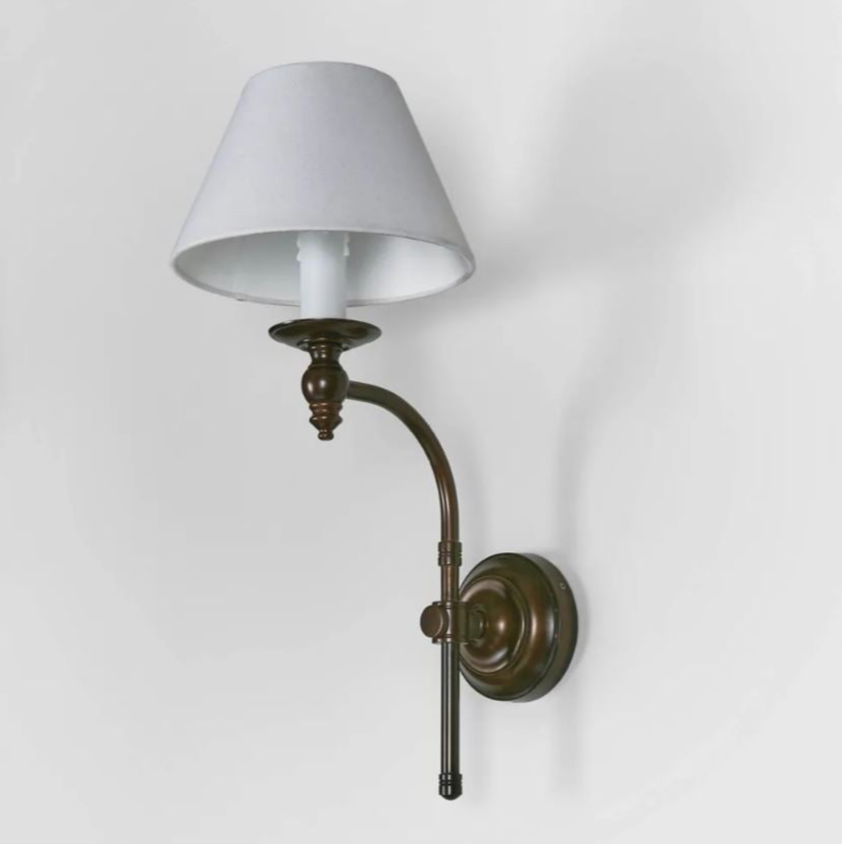 Wall-mounted lamp with a white shade and bronze fixture on a light gray background