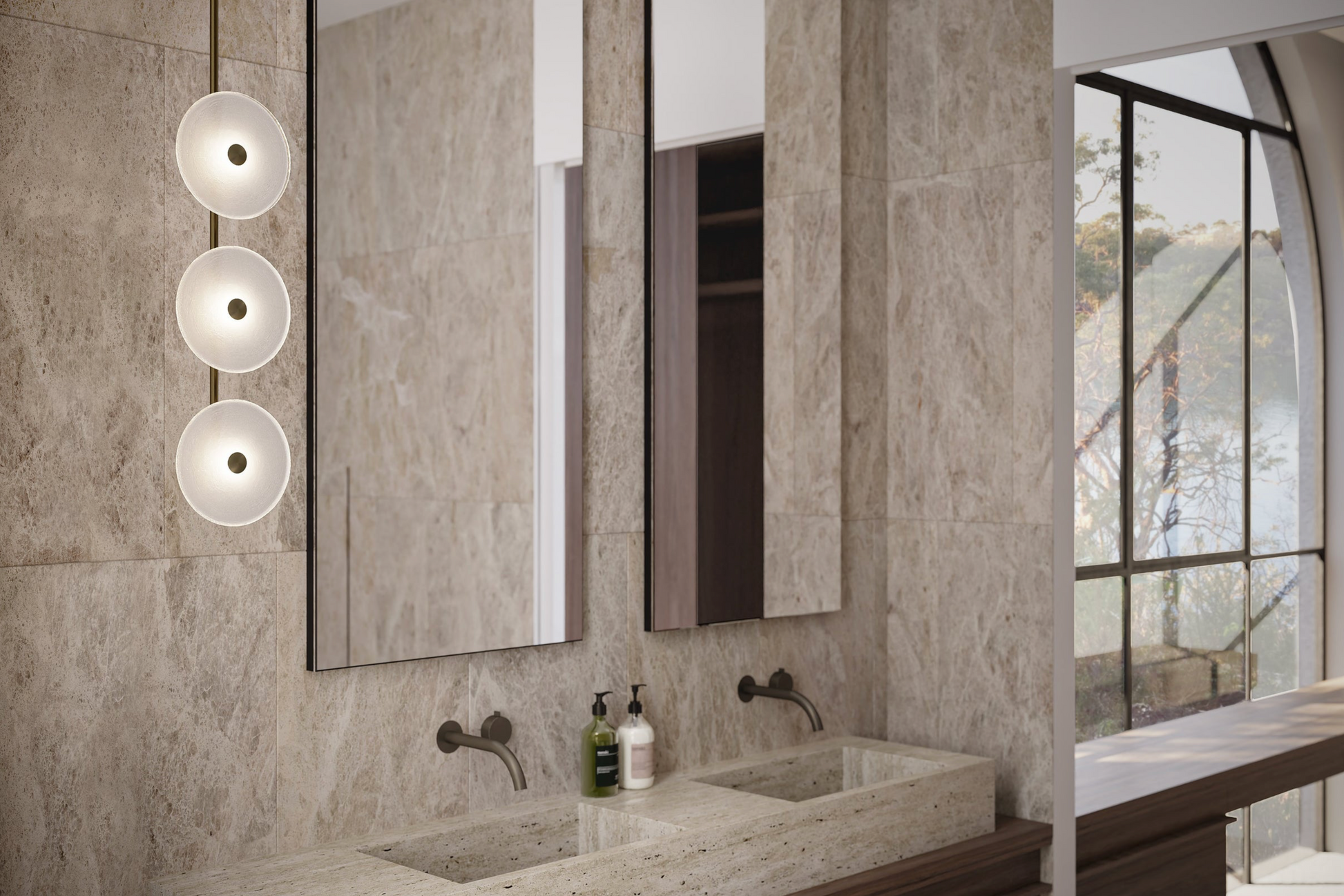 Modern bathroom with marble walls, sinks, and glass lighting fixtures.