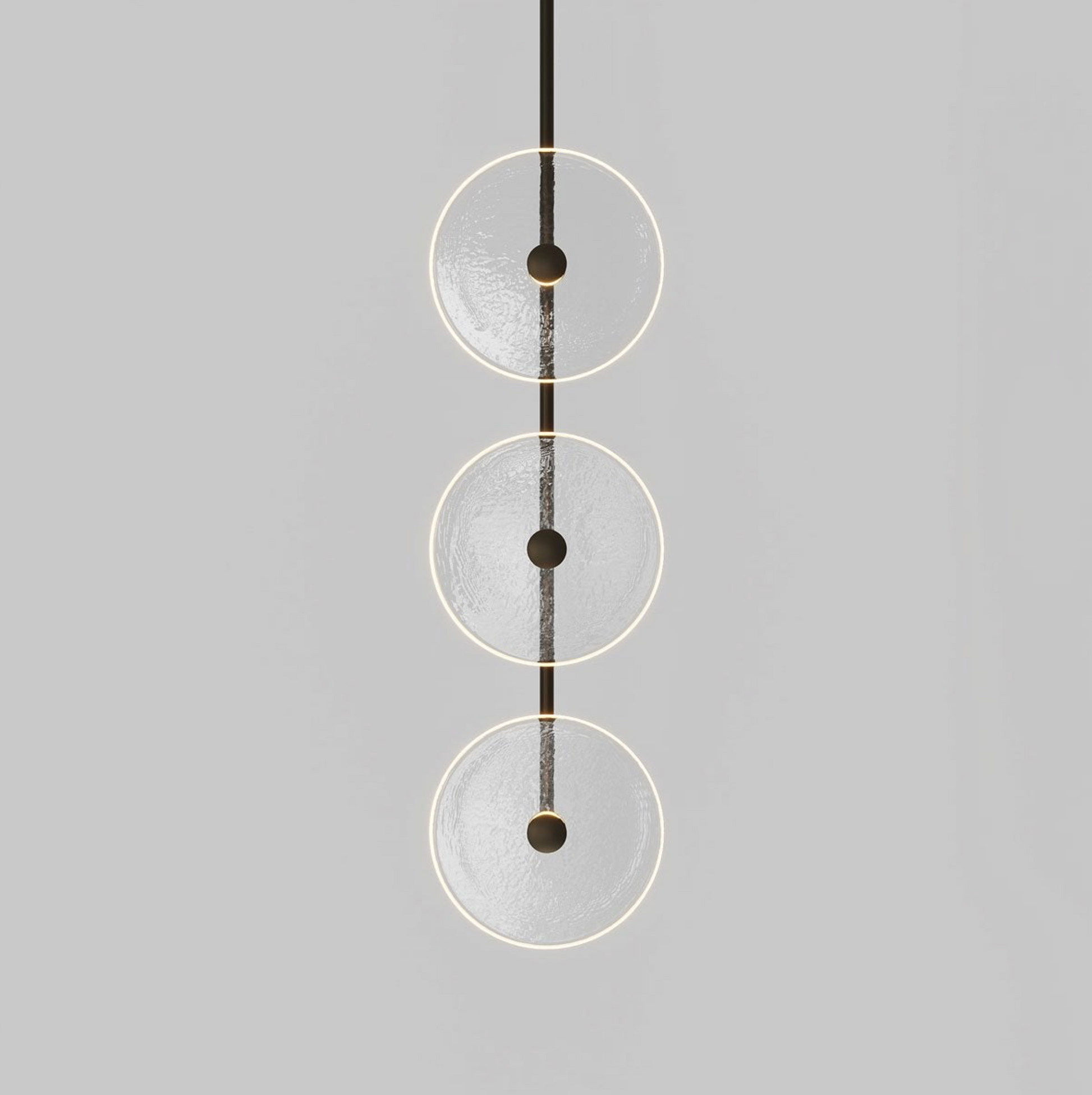 Modern pendant light with three glass circular shades on a grey background