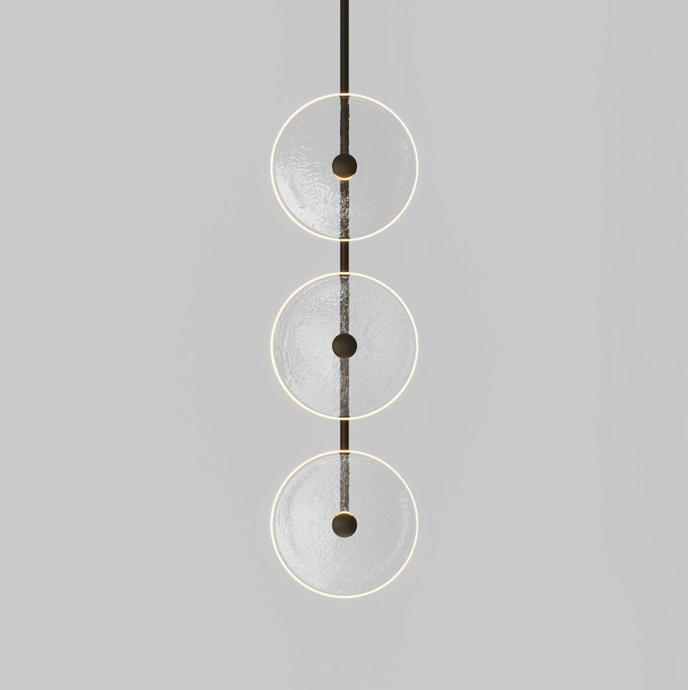 Modern pendant light with three glass circular shades on a grey background