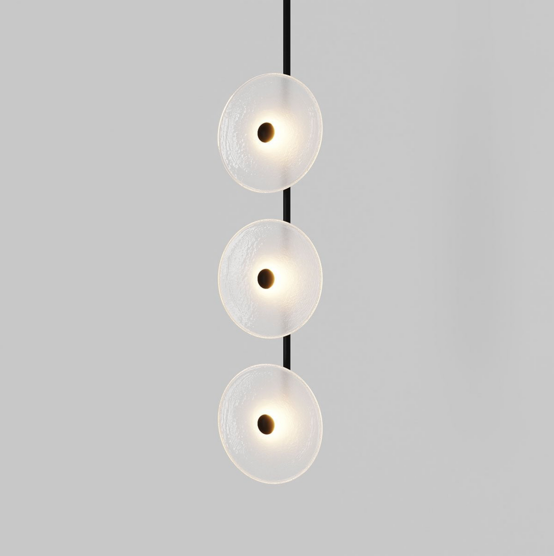 Modern pendant light with three round glass shades on a gray background