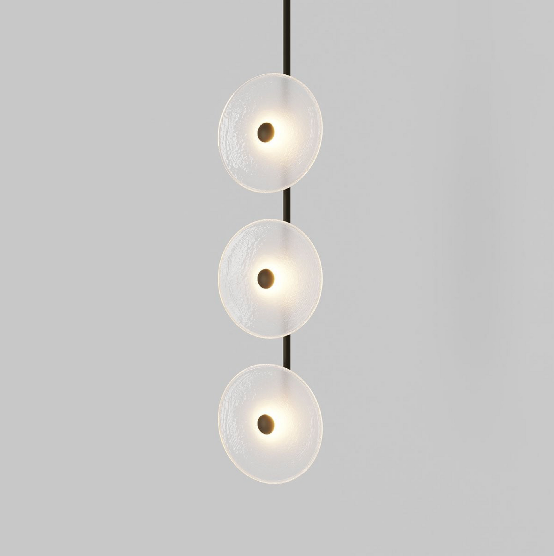 Modern pendant light with three round glass shades on a gray background