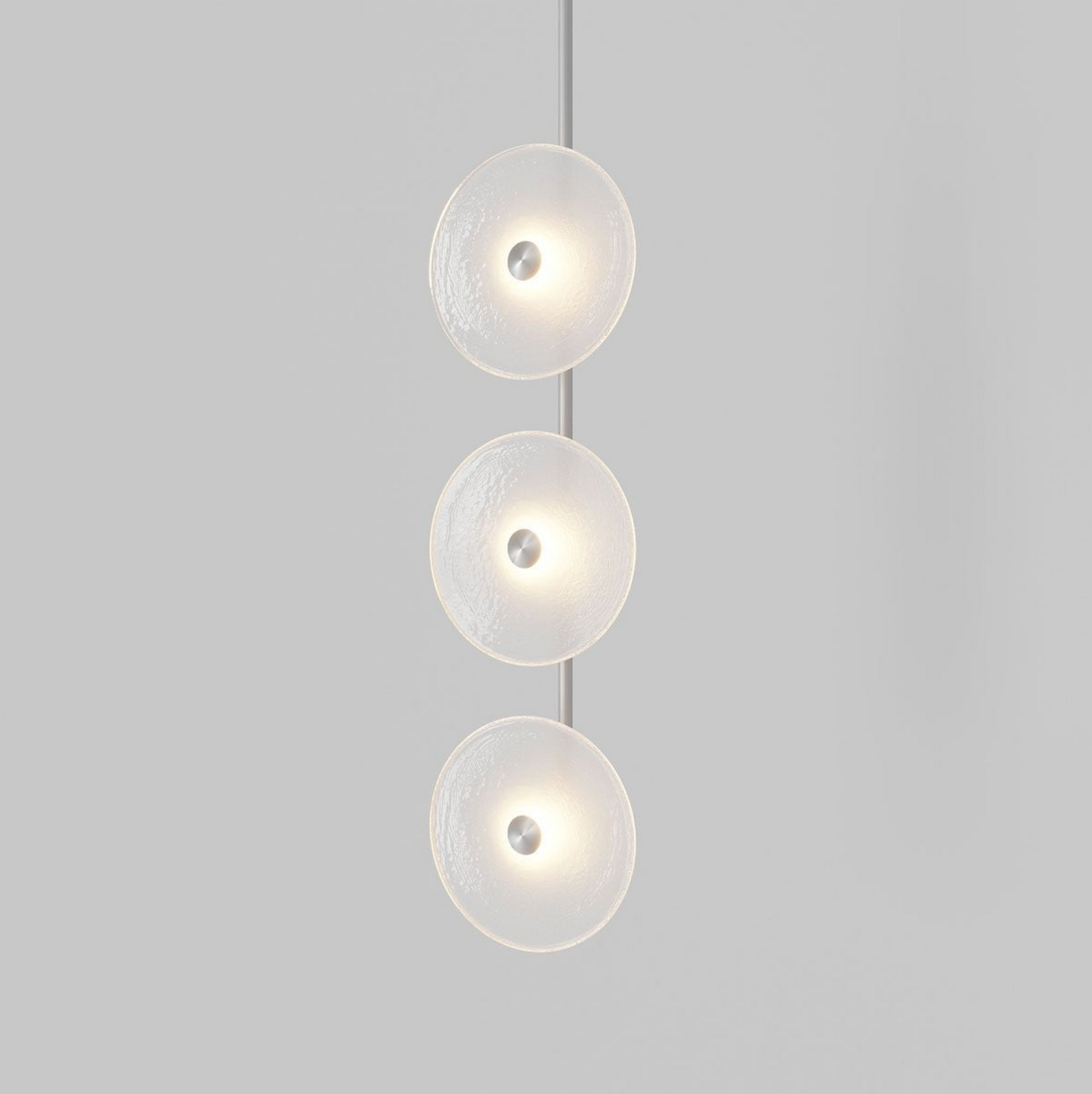 Modern pendant light with three circular glass shades on a gray background